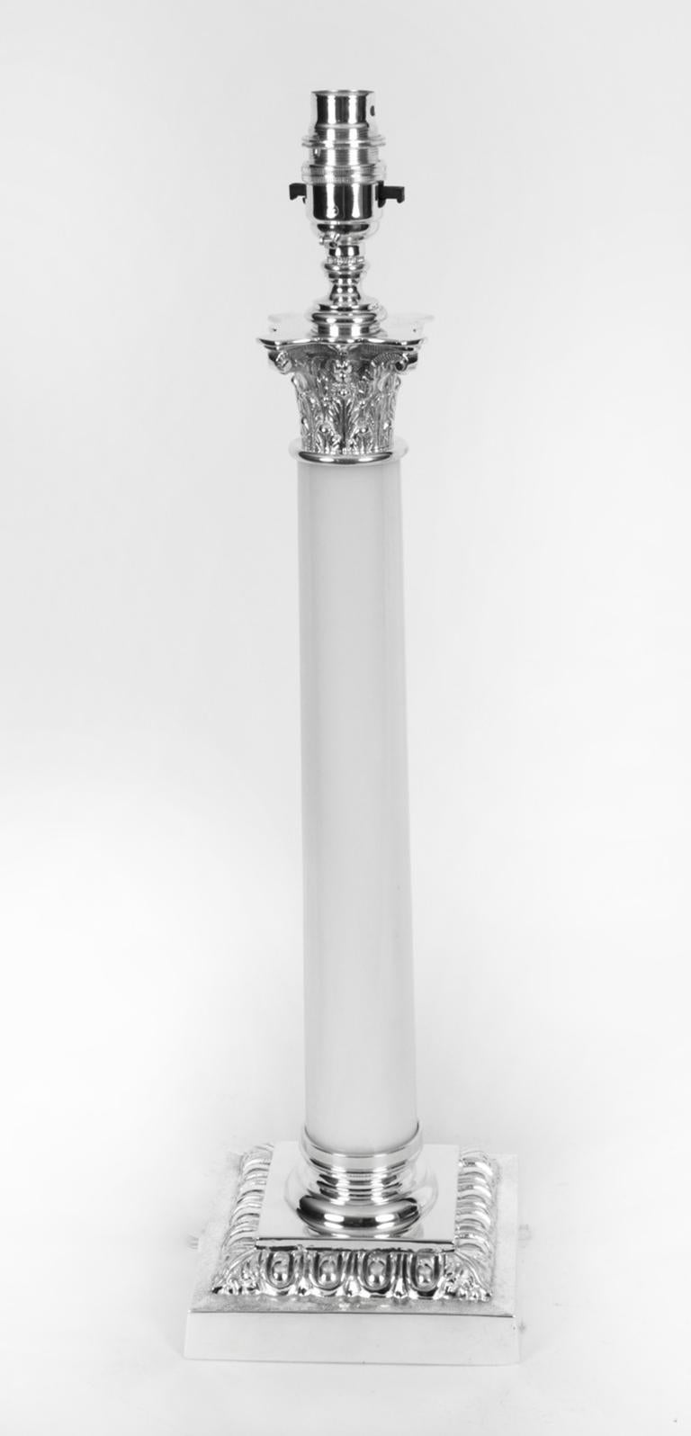 Il s'agit d'une splendide paire ancienne de lampes de table à colonne corinthienne en métal argenté et verre opalin, maintenant converties à l'électricité, datant d'environ 1920.

Elle présente un chapiteau corinthien classique décoré de feuilles