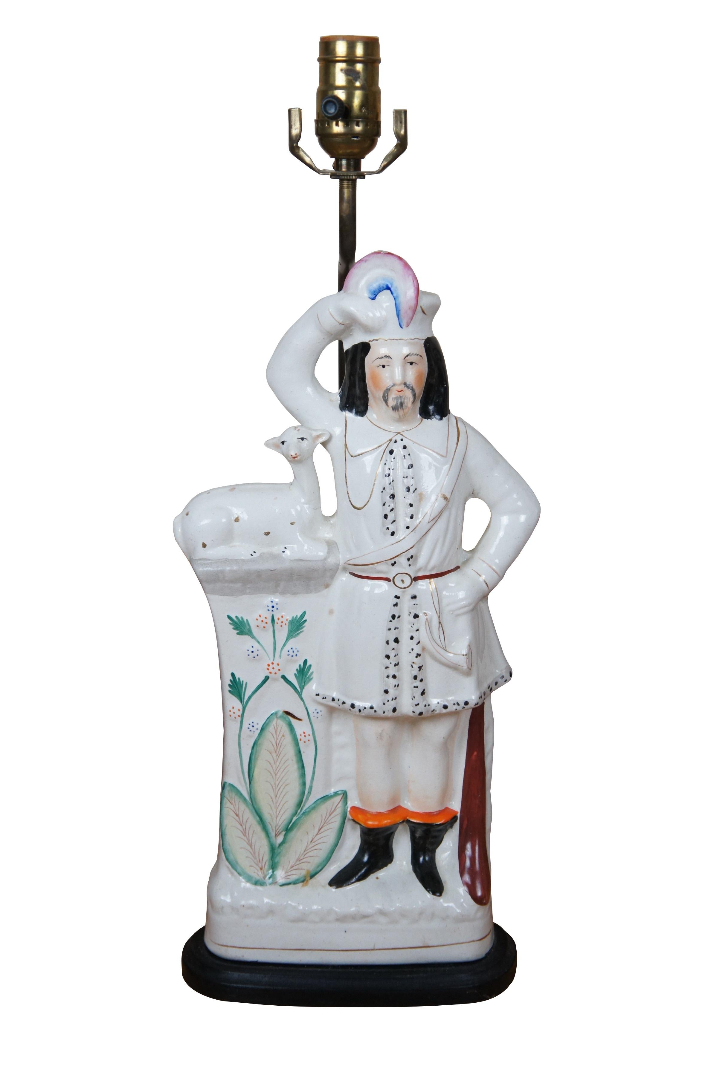 Paire de figurines anciennes du 19e siècle en porcelaine anglaise du Staffordshire transformées en lampes de table, représentant une paire d'hommes en costume des Highlands écossais, debout à côté de piliers surmontés d'animaux/de faons couchés.