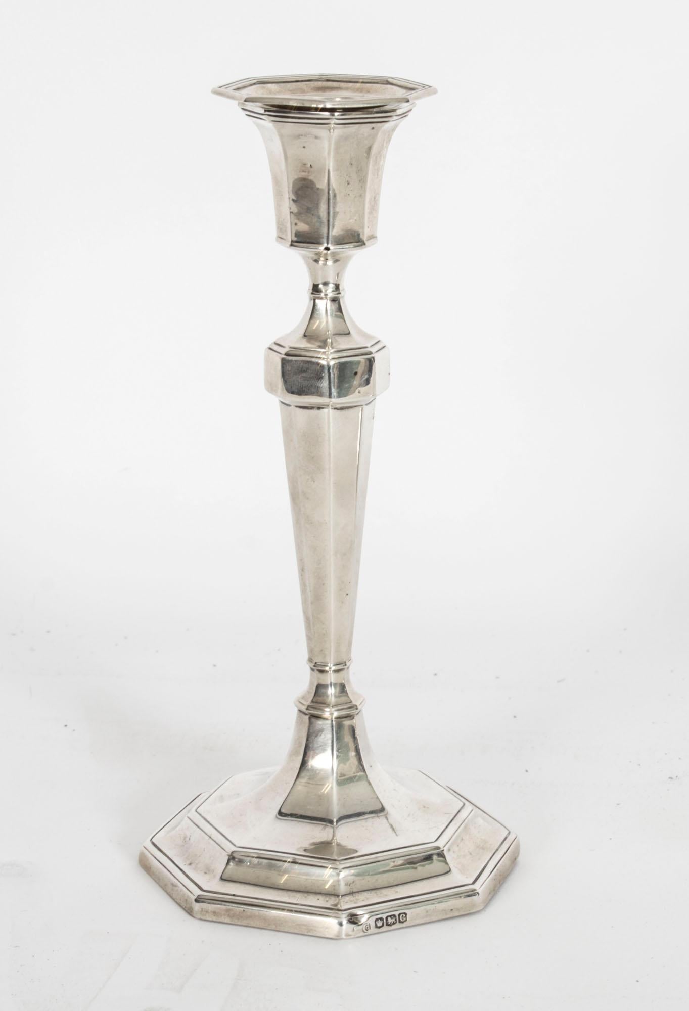 This is an exquisite pair of 1920s sterling silver candlesticks of tapering octagonal form, with separate sconces, on octagonal pedestal bases bearing hallmarks for Sheffield, dated 1920 and the makers mark of the renowned English silversmith