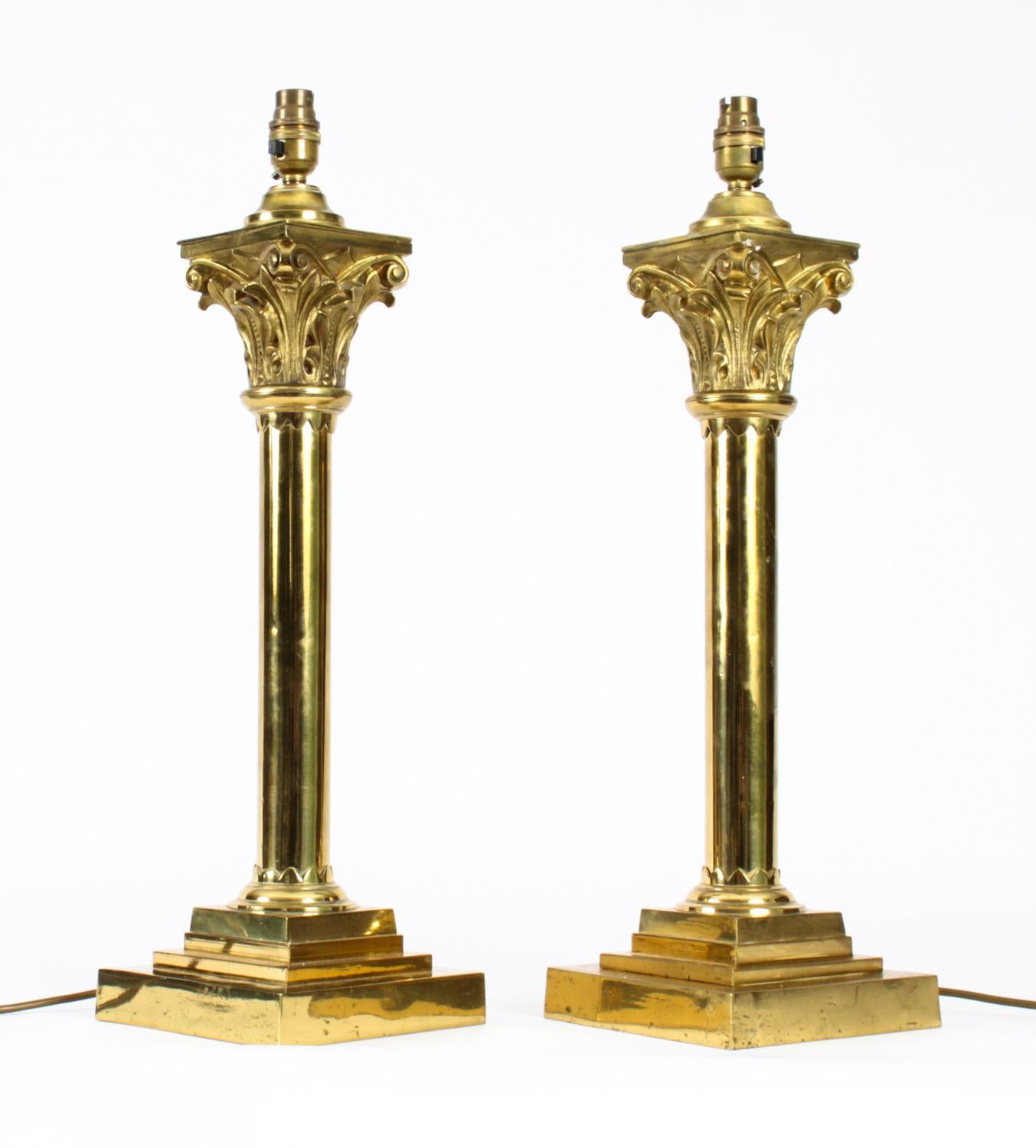 This is a splendid pair of antique Victorian brass columnar Corinthian column table lamps, now converted to electricity from oil lamps, late 19th century in date.

This opulent pair of antique table lamps feature Kingly Corinthian Capitals