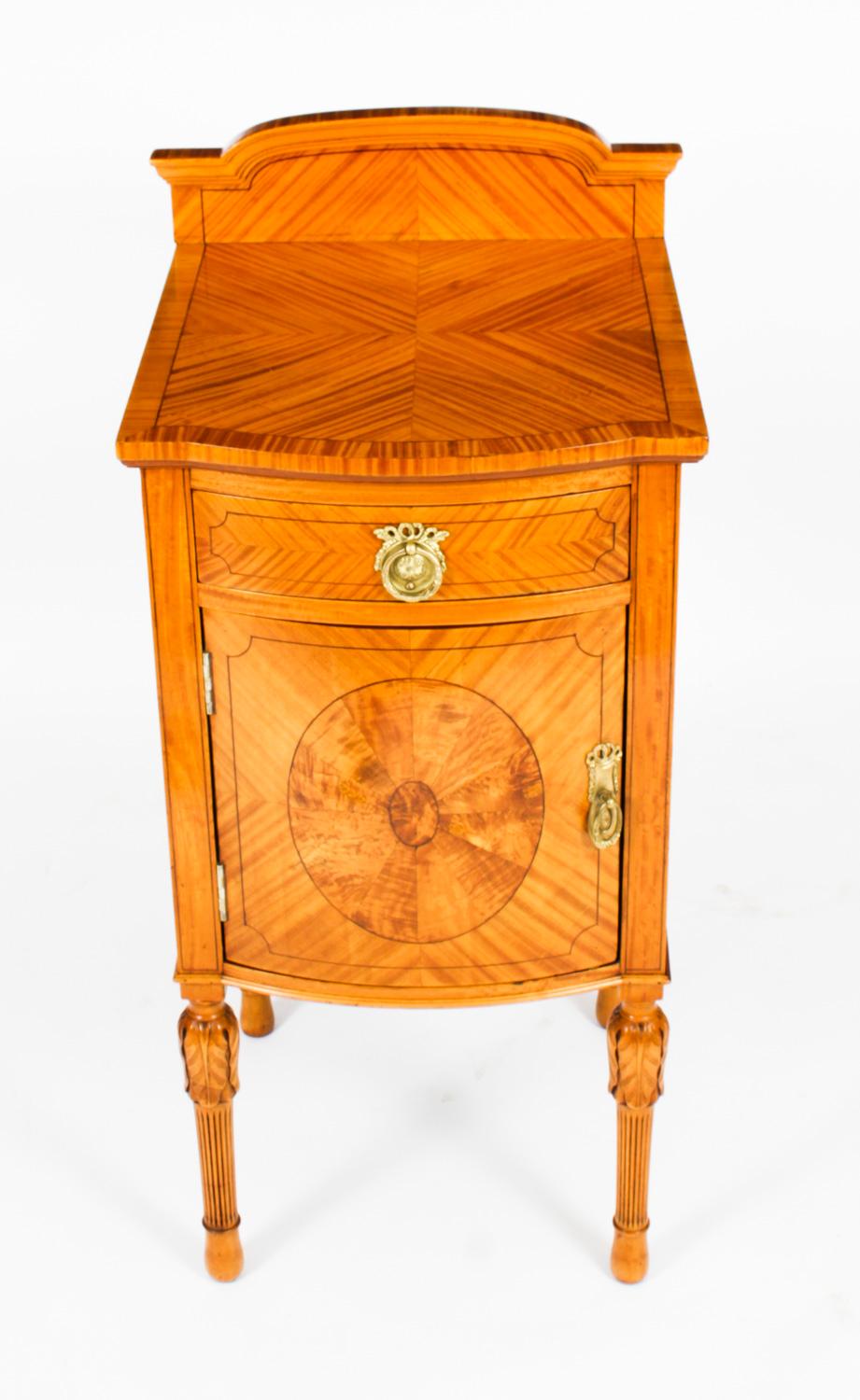 This is a stunning pair of Antique Victorian satinwood bow-front bedside cabinets, circa 1890 in date.

They are crafted from the most beautiful satinwood with decorative banding and box wood inlaid stringing. Each cabinet with a frieze drawer