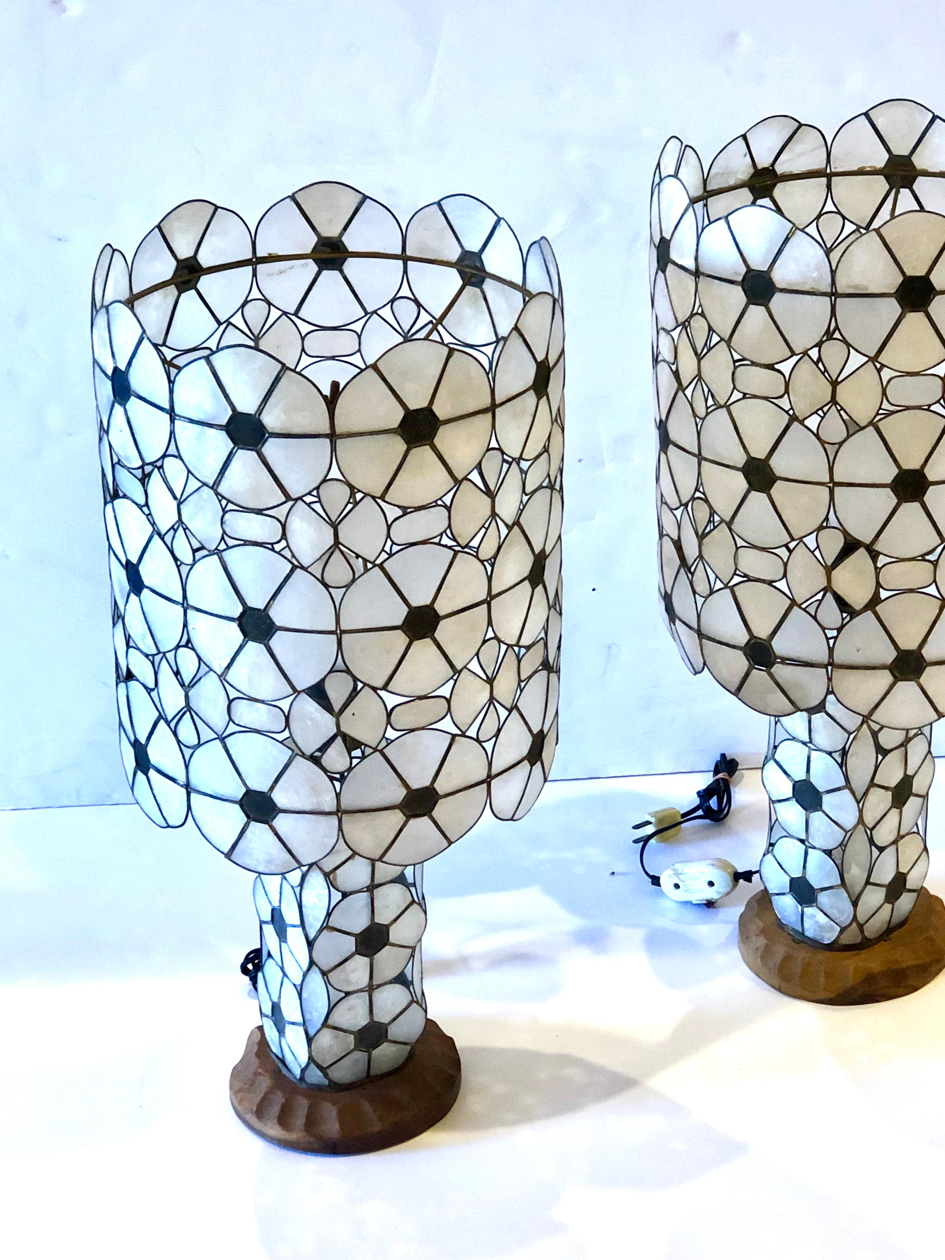 Beautiful and rare pair of delicate handmade capiz shells lamps with brass, sitting on monkey pod wood bases freshly rewired, very delicate and beautiful pieces, the lamp shades come off.