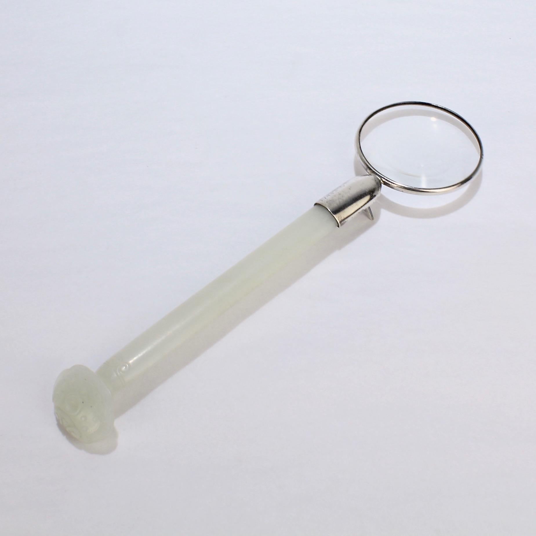 A fine antique jade mounted as a magnifying glass.

In the form of a Ruki shaped hairpin. The glass is framed in a silver tone metal and supported with an A-frame splayed foot.

The nephrite jade is pale celadon in color. 

The magnifying glass was