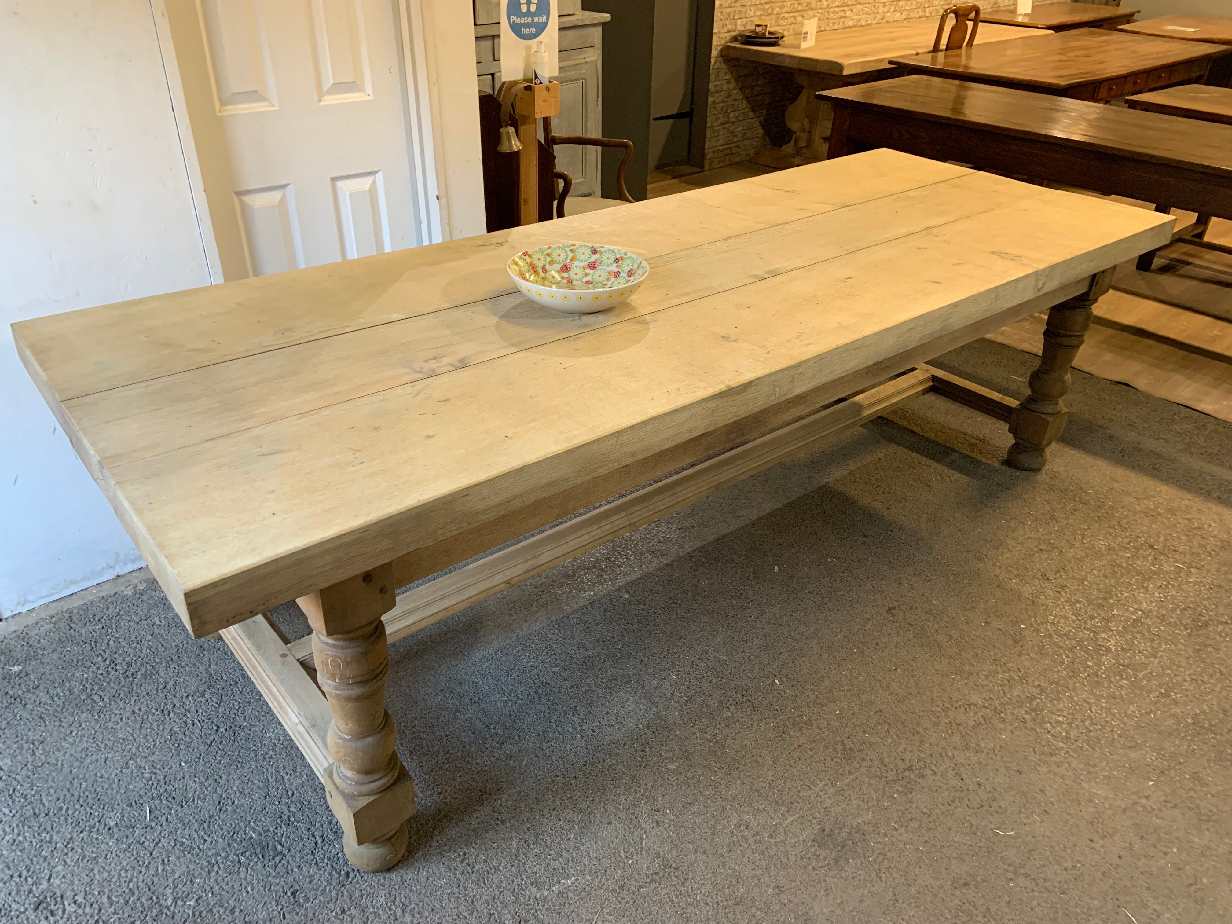 Antique pale oak farmhouse table with thick top and lovely round legs. The base is joined with a centre stretcher and is very sturdy. The top of this does come off so this makes it easier for transportation. The knee height is very good at the