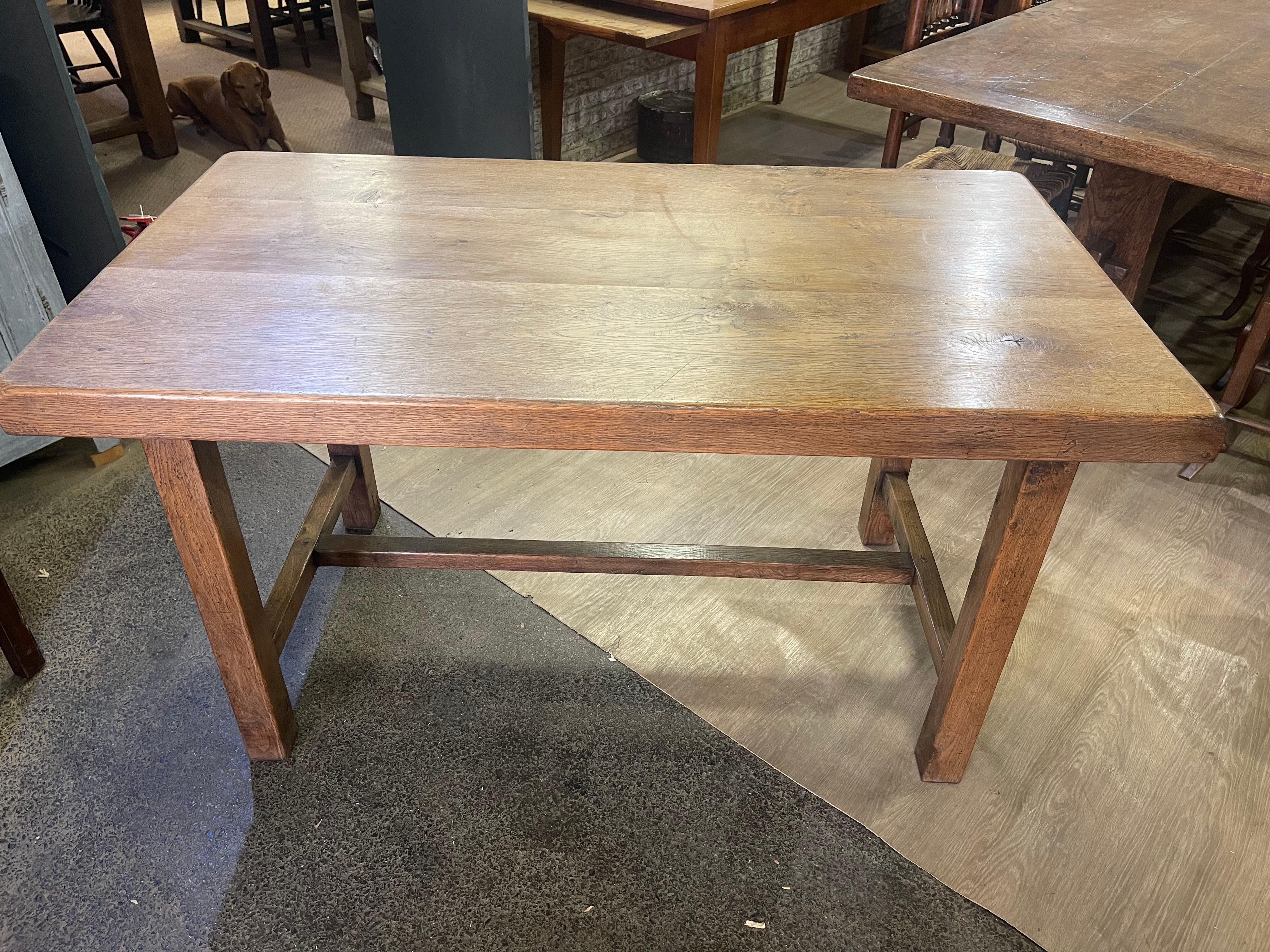 Esta exquisita mesa antigua presenta un robusto tablero grueso de roble pálido, que desprende un encanto intemporal que realza cualquier comedor.  La robusta base se ha diseñado para ofrecer durabilidad y estabilidad, y la estructura se refuerza con