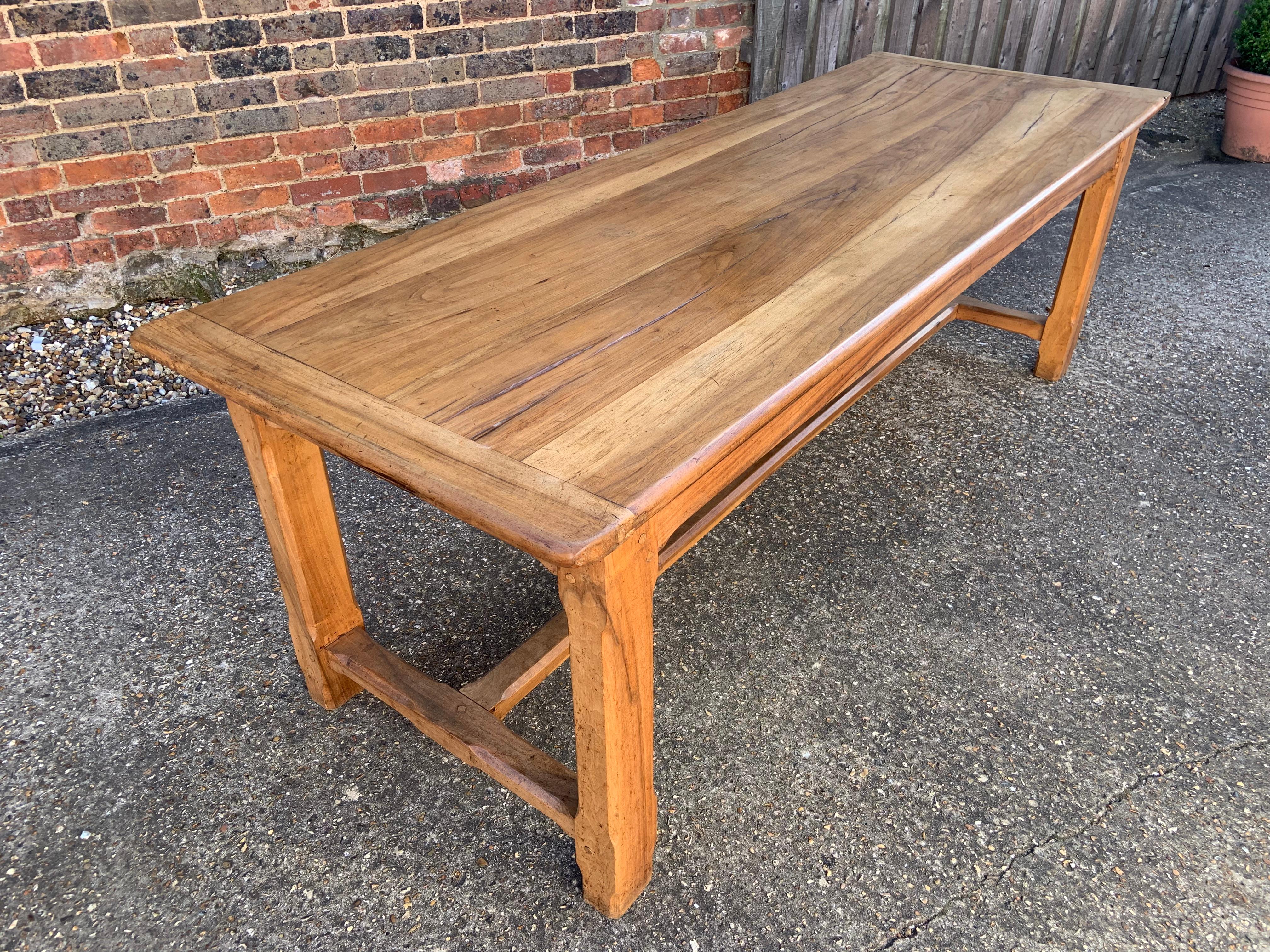 Antique pale walnut H stretcher table with a four plank top with cleated ends The top is 1.5