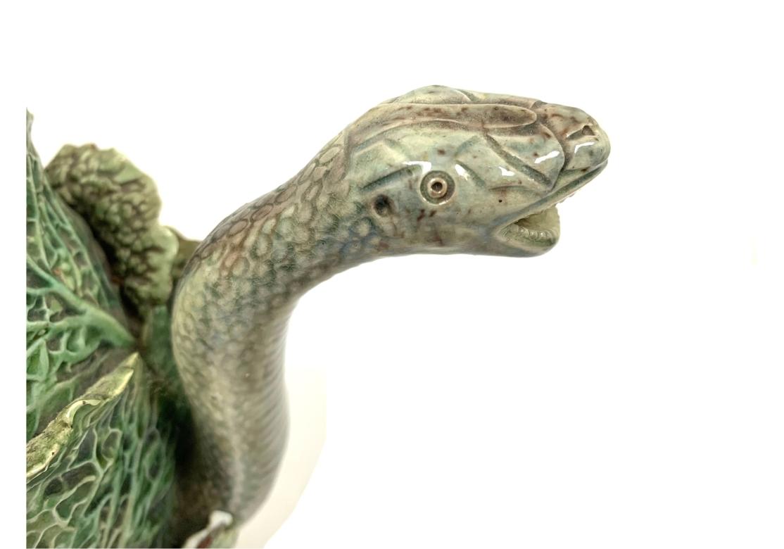 Rare théière ancienne en majolique de Palissy avec bec sinueux en forme de serpent et poignée en forme de queue enroulée. Le serpent sort d'une tête de chou feuillu et est surmonté d'une base ronde en gradins. Fabriqué au Portugal.

Dimensions : 10