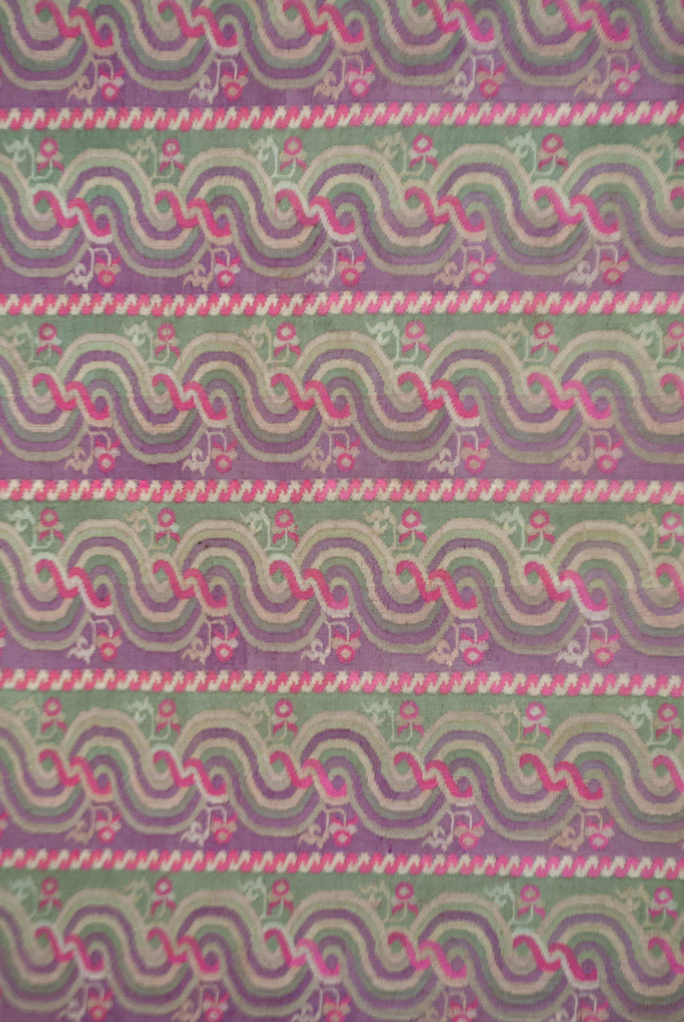 Antique Panel from Young Girl’s Luntaya-Acheiq Hta-mein (skirt), Myanmar (Burma)

Skirt panel of interlocking-tapestry woven silk in three shades of jade green, purple, reddish pink, cream and white. The layout is of horizontal bands of repeating