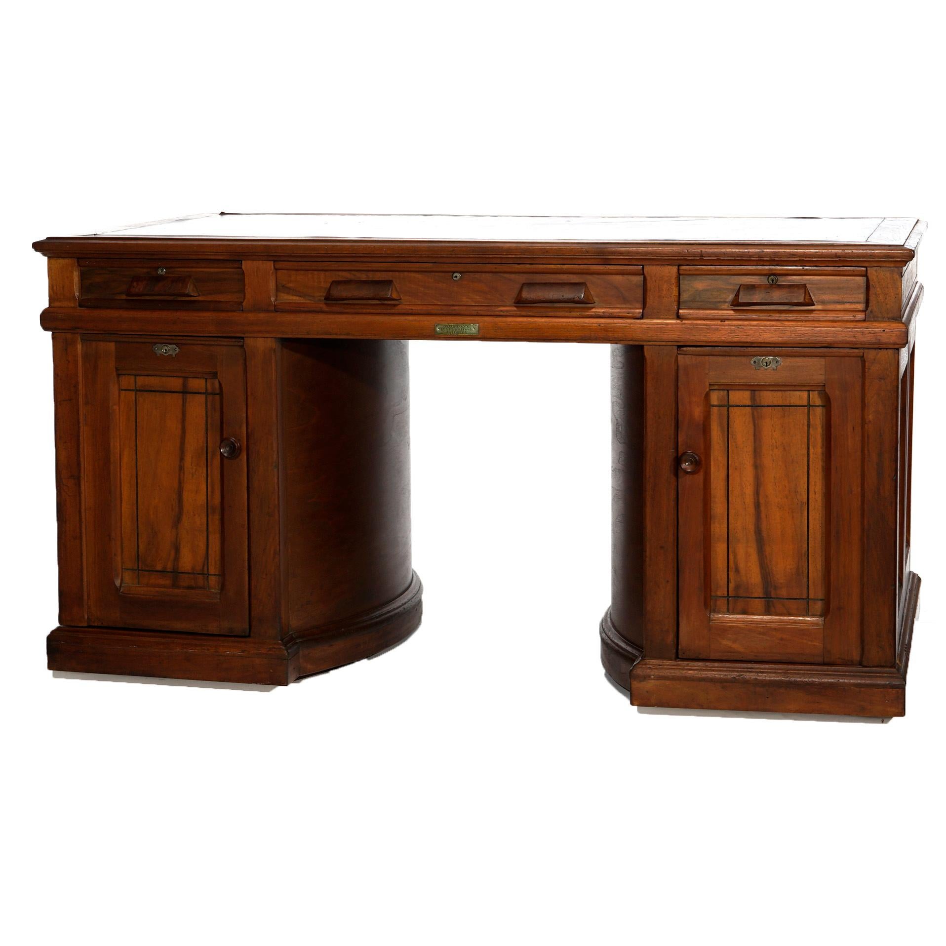 An antique rotary desk by Wooton offers walnut paneled construction with leather top over case having upper drawers and rotary sides opening to catalogue and file compartments, identifying label as photographed, c1890

Measures- 31''H x 60''W x