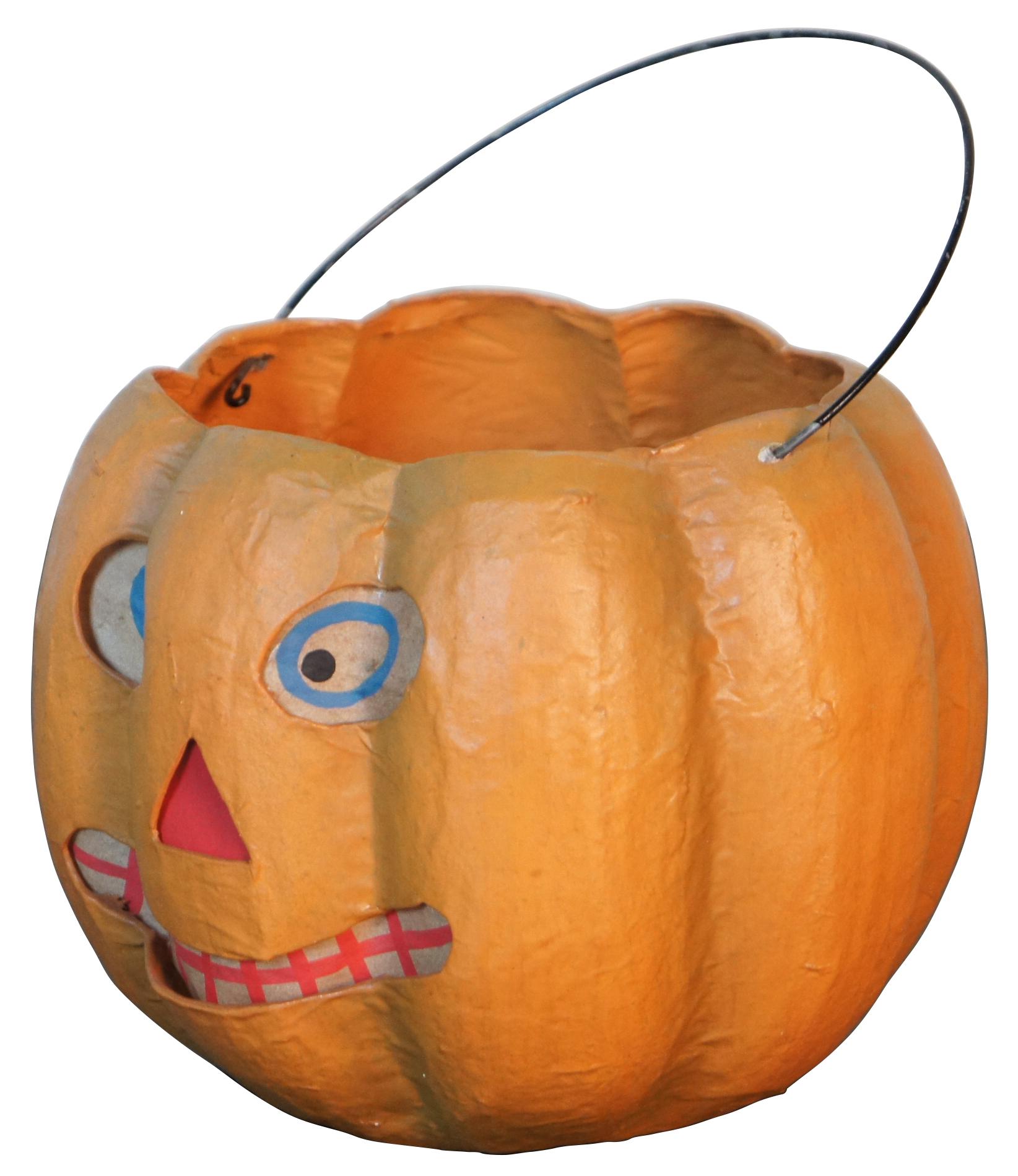 Antique paper mache jack-o-lantern shaped candy bucket with paper backed, cut out face and wire handle.
 