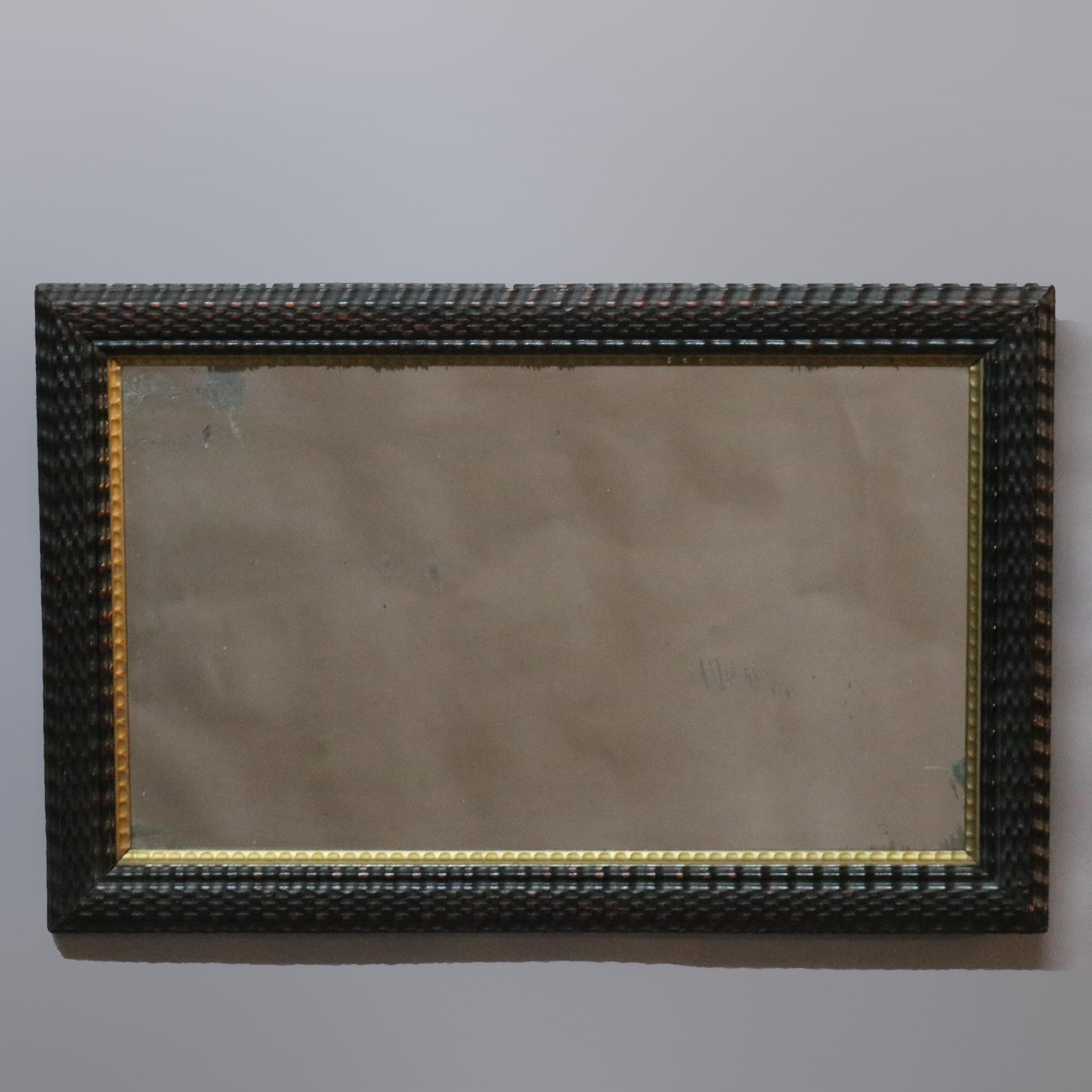 An antique wall mirror offers ebonized carved ripple wood frame with gilt inner trim, 19th century

Measures: 18.25