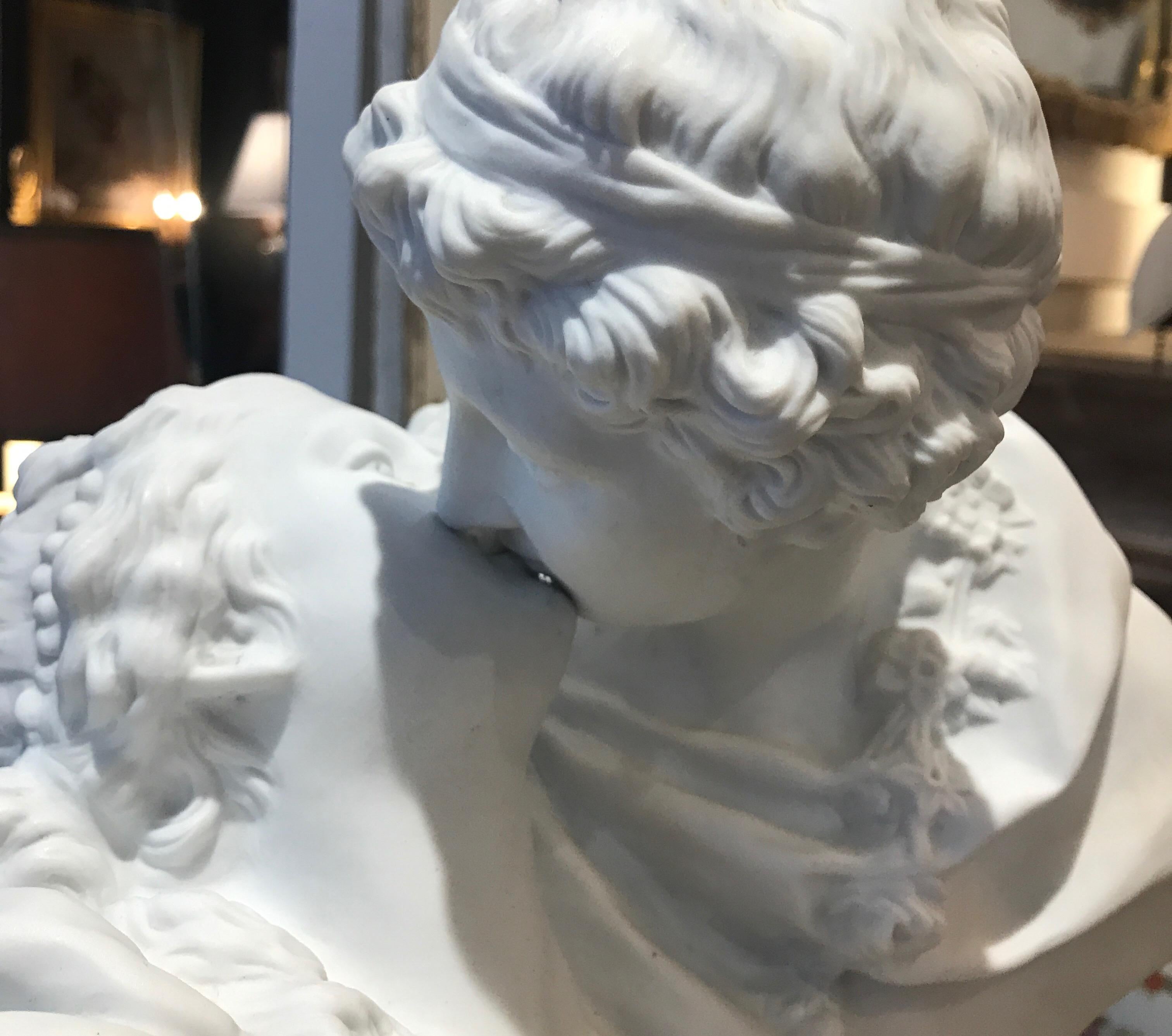 A white porcelain bisque porcelain sculpture of a man and woman in romantic pose. 
