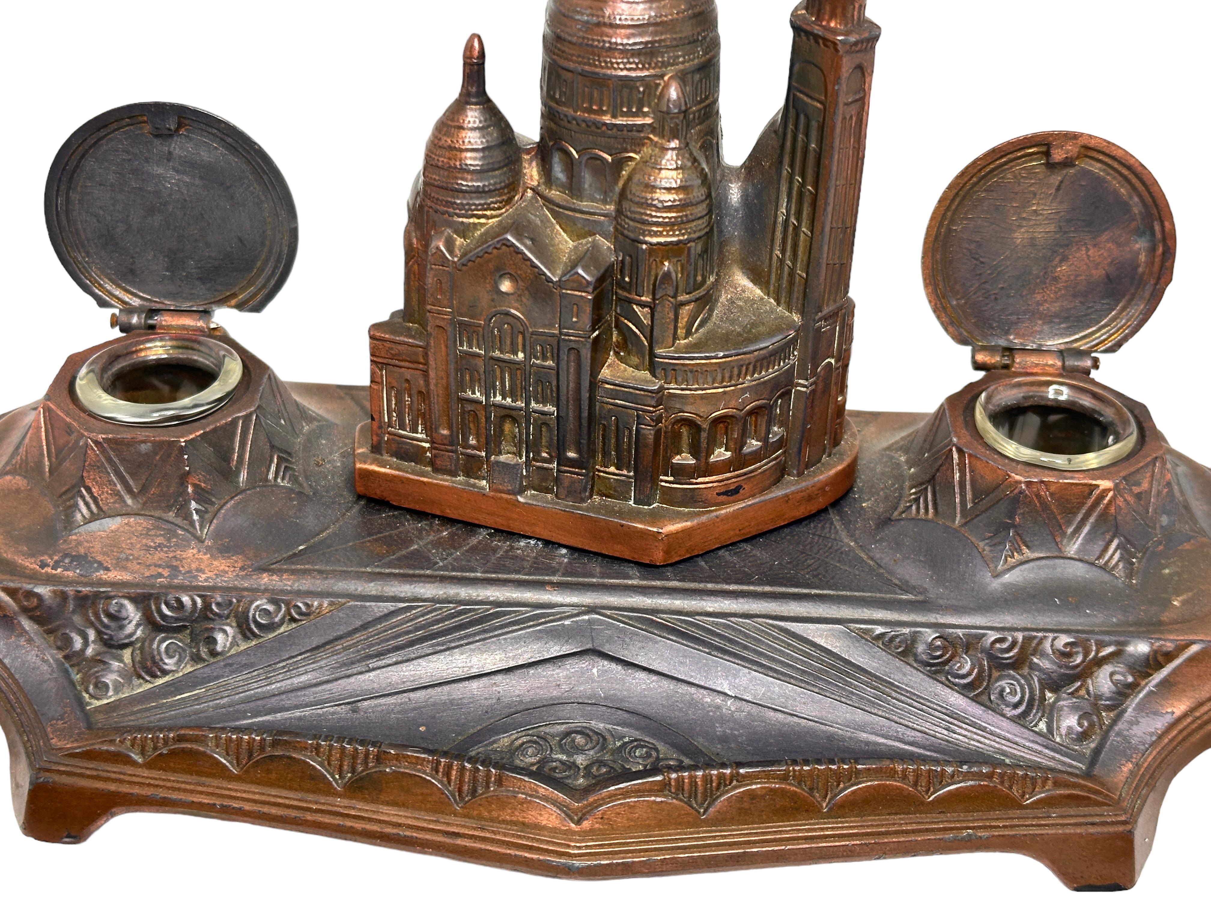 Classic early 1900s - 1910s double inkwell, with a souvenir building of The Basilica of the Sacred Heart of Paris. Nice addition to your writing desk or just to display them in your room. Found at an estate sale in Vienna, Austria. 
The Inkwell is