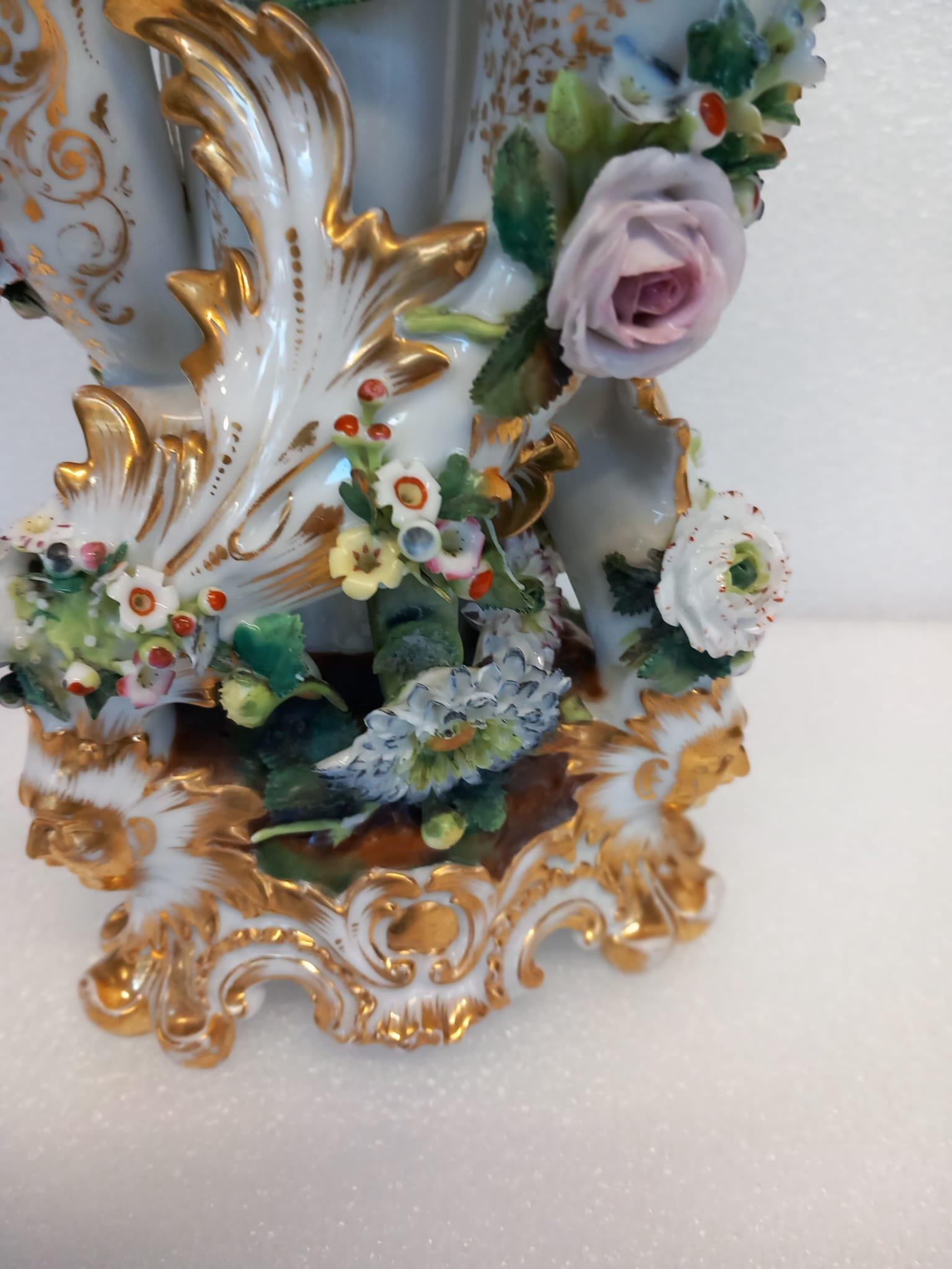 An unusual antique Paris porcelain vase in the shape of an épergne with a large central flower holder and two smaller ones on either side. 
Heavily encrusted with porcelain moulded flowers and decorated with gold leaf designs, moulded in white