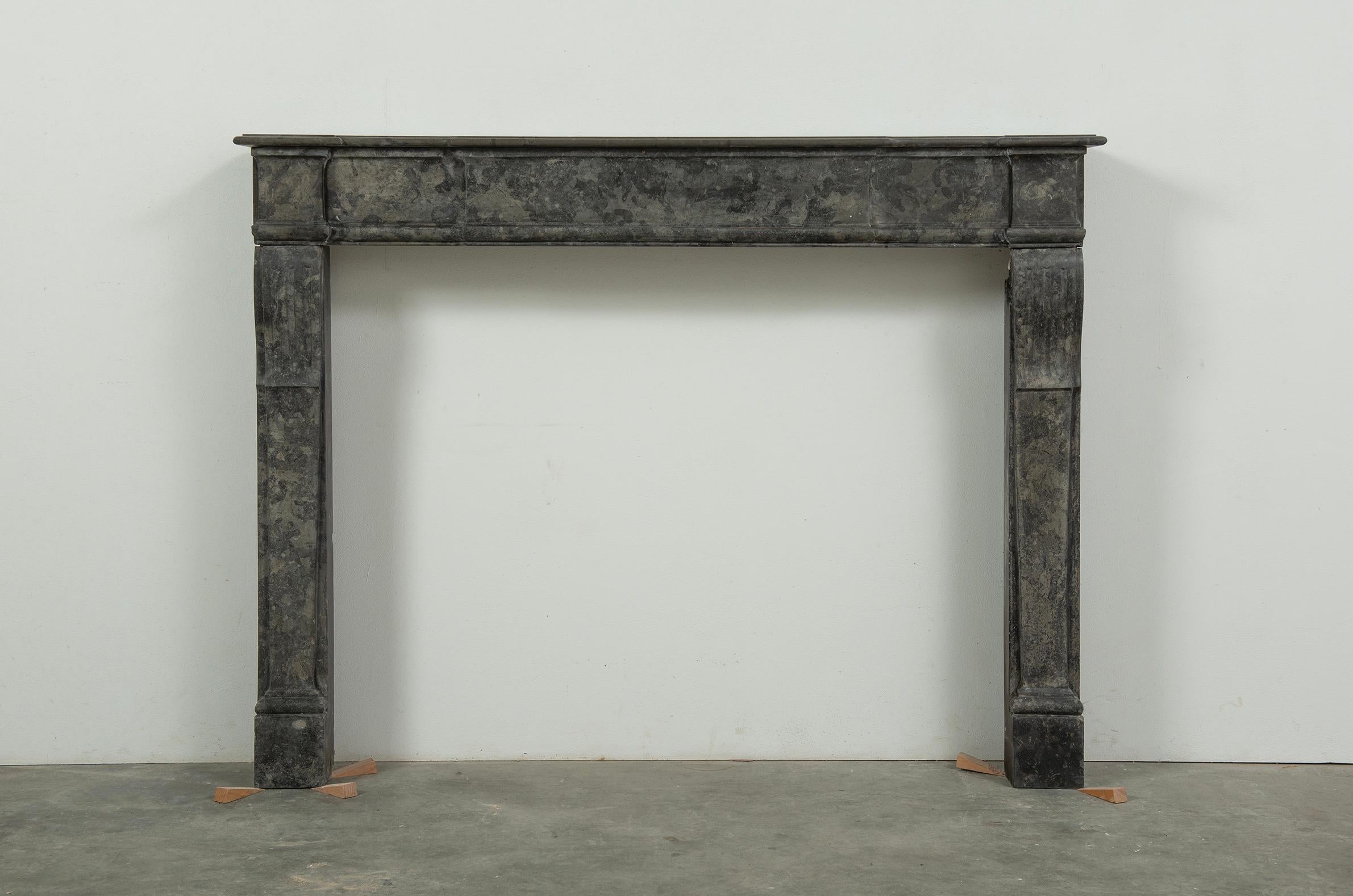 This exquisite antique Parisian Louis XVI-style fireplace embodies elegance and timeless sophistication. Crafted from a striking black and gray marble, its understated beauty makes it a refined focal point for any interior. The clean lines, balanced