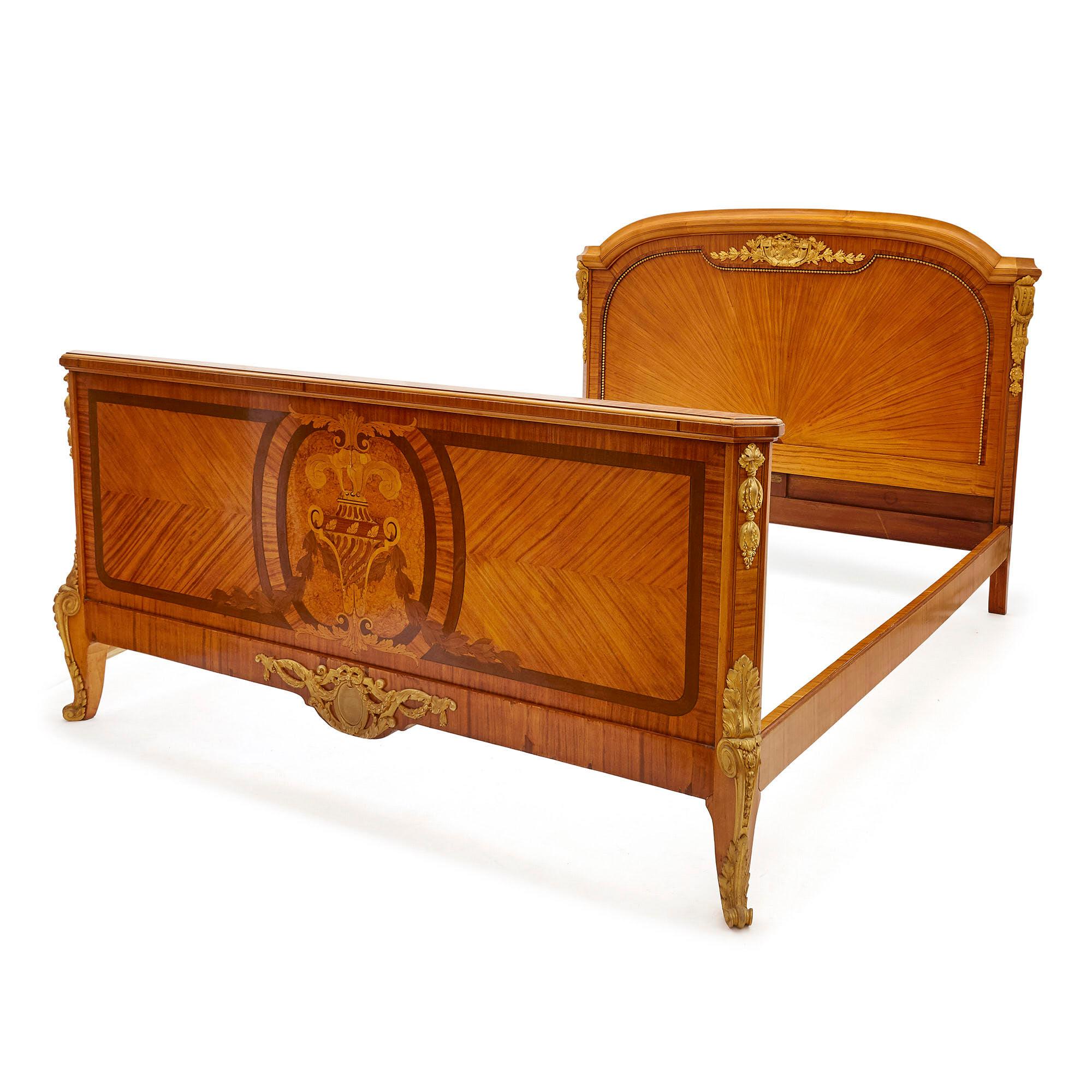 Antique Parisian Marquetry and gilt bronze bed by Au Gros Chêne
French, late 19th century
Dimensions: Height 127cm, width 167cm, depth 212cm

This elegant bed is designed in the late 19th Century French Neoclassical style, retailed by Parisian