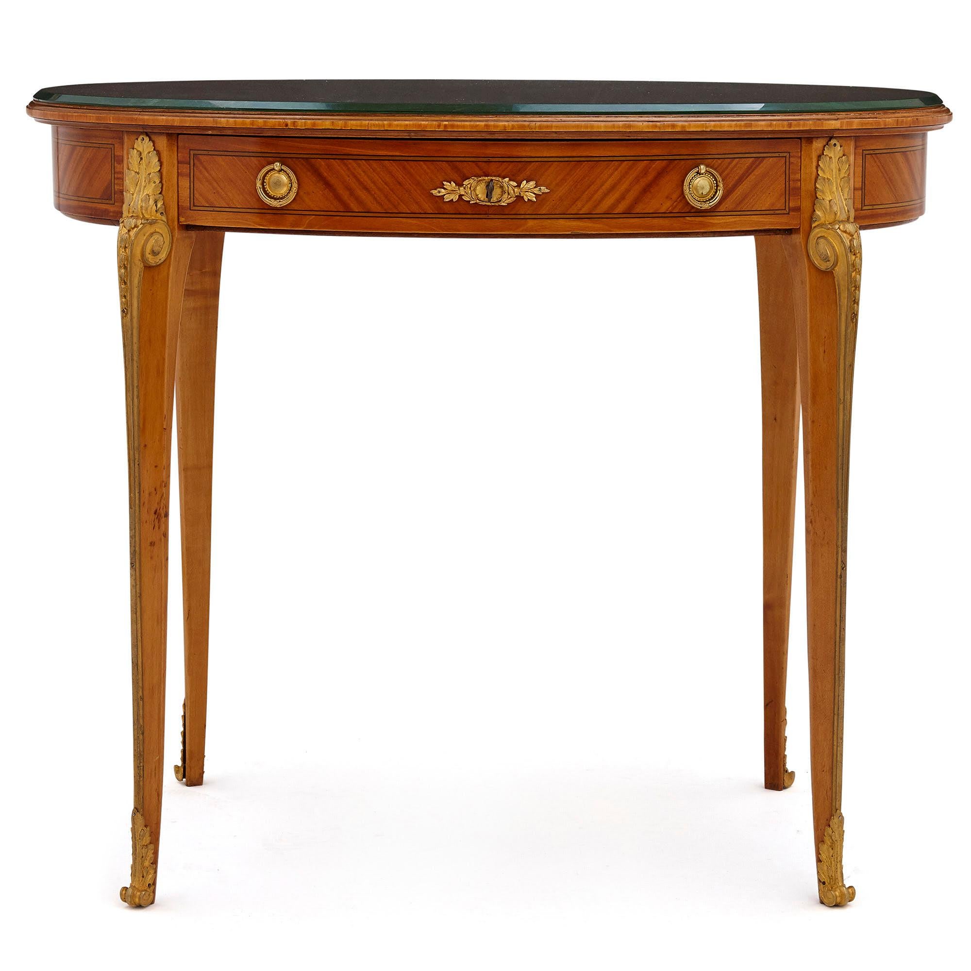 Antique Parisian neoclassical style side table by Au Gros Chêne,
French, late 19th century
Dimensions: Height 75cm, width 90cm, depth 59cm

This elegant oval shaped side table is designed in the late 19th century French Neoclassical style,