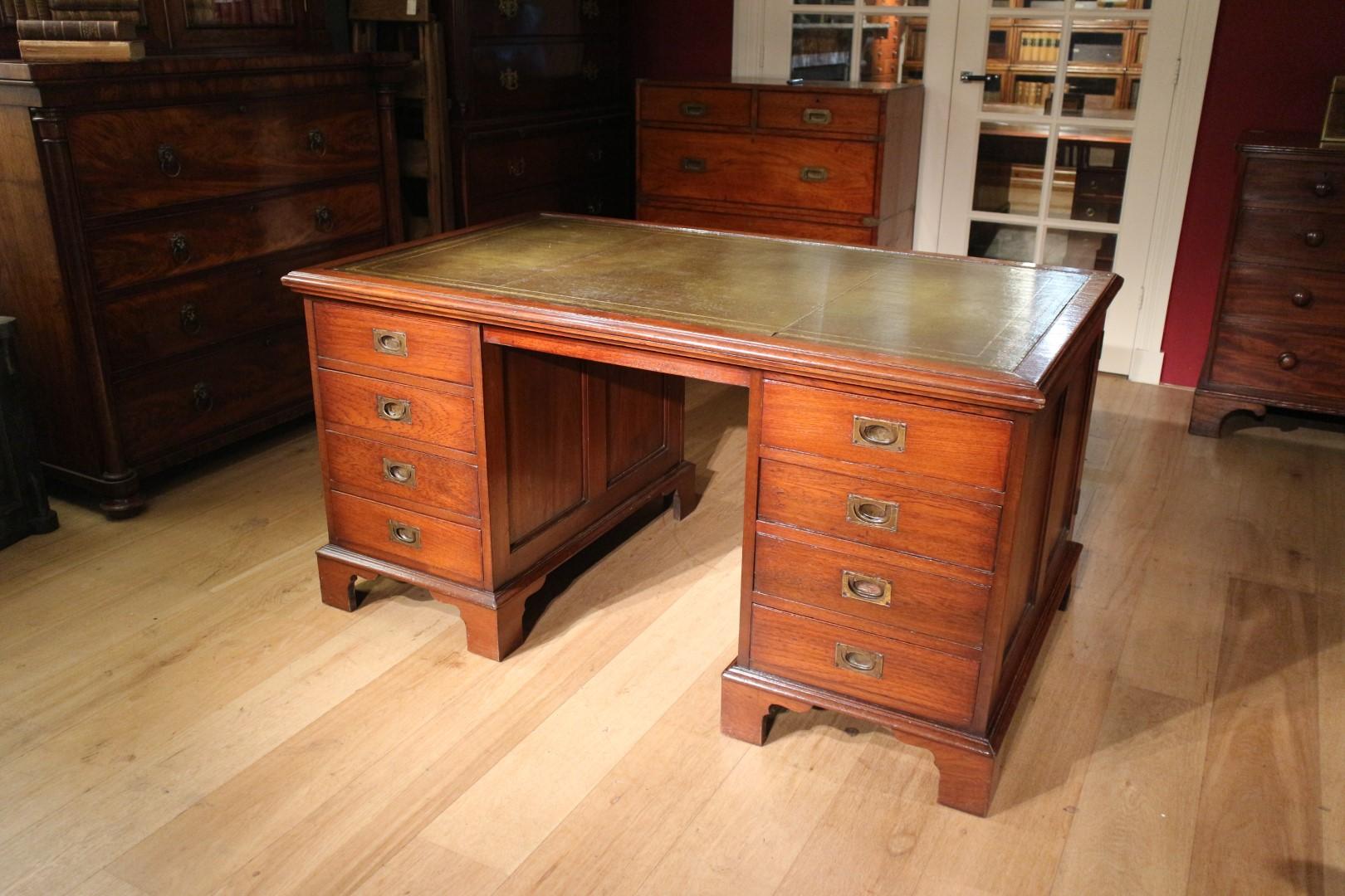 Beautiful antique teak partners desk that can be used from 2 sides. Entirely in very good condition. Green gold-edged leather top. The desk has no drawer in the middle and therefore plenty of legroom. One side has 8 drawers with the characteristic