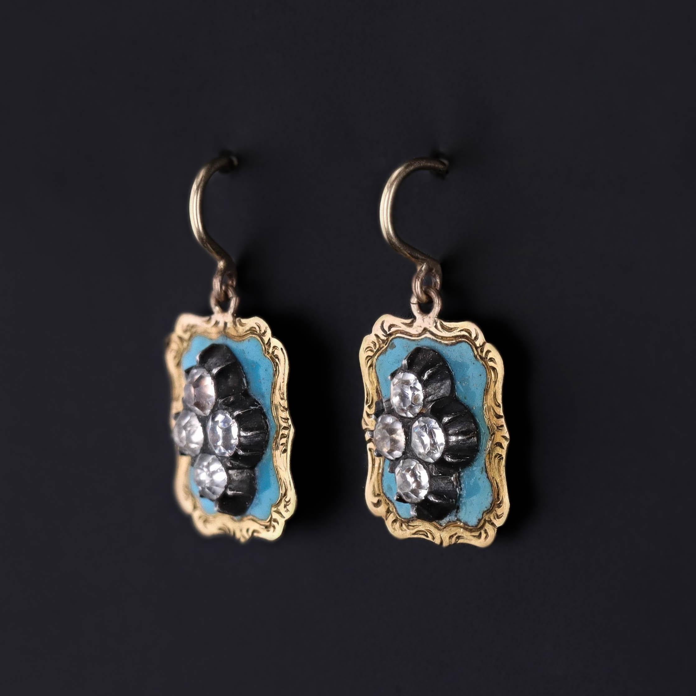 Irradiant la douce élégance de l'ère victorienne, cette ravissante paire de boucles d'oreilles anciennes (vers 1870) présente des pierres en pâte (verre) lumineuses serties sur un délicat fond d'émail bleu ciel, créant ainsi un look à la fois