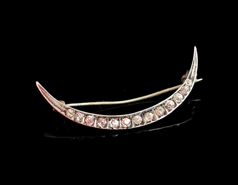 A gorgeous antique, c1900s, sterling silver and paste crescent brooch.

A beautiful open crescent in cool silver, it is set with colourless paste that graduate from the ends to centre.

Crescent moons were a popular motif in Victorian jewellery,