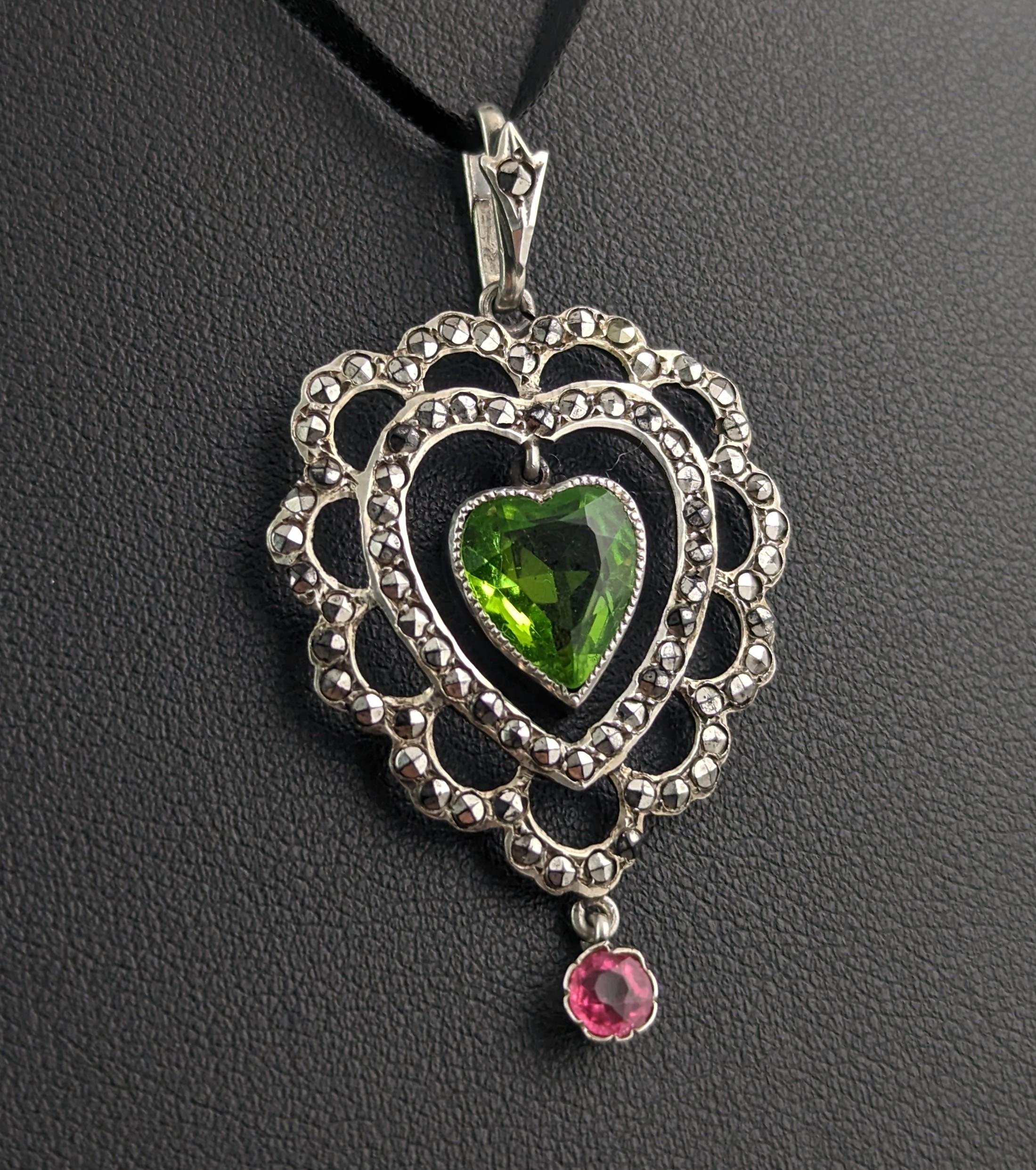 A beautiful antique Art Deco era paste heart dropper pendant.

Crafted in 800 silver it is likely a German made piece, it features a stylised open heart design with an almost floral like outer border all set with twinkling marcasite.

To the centre