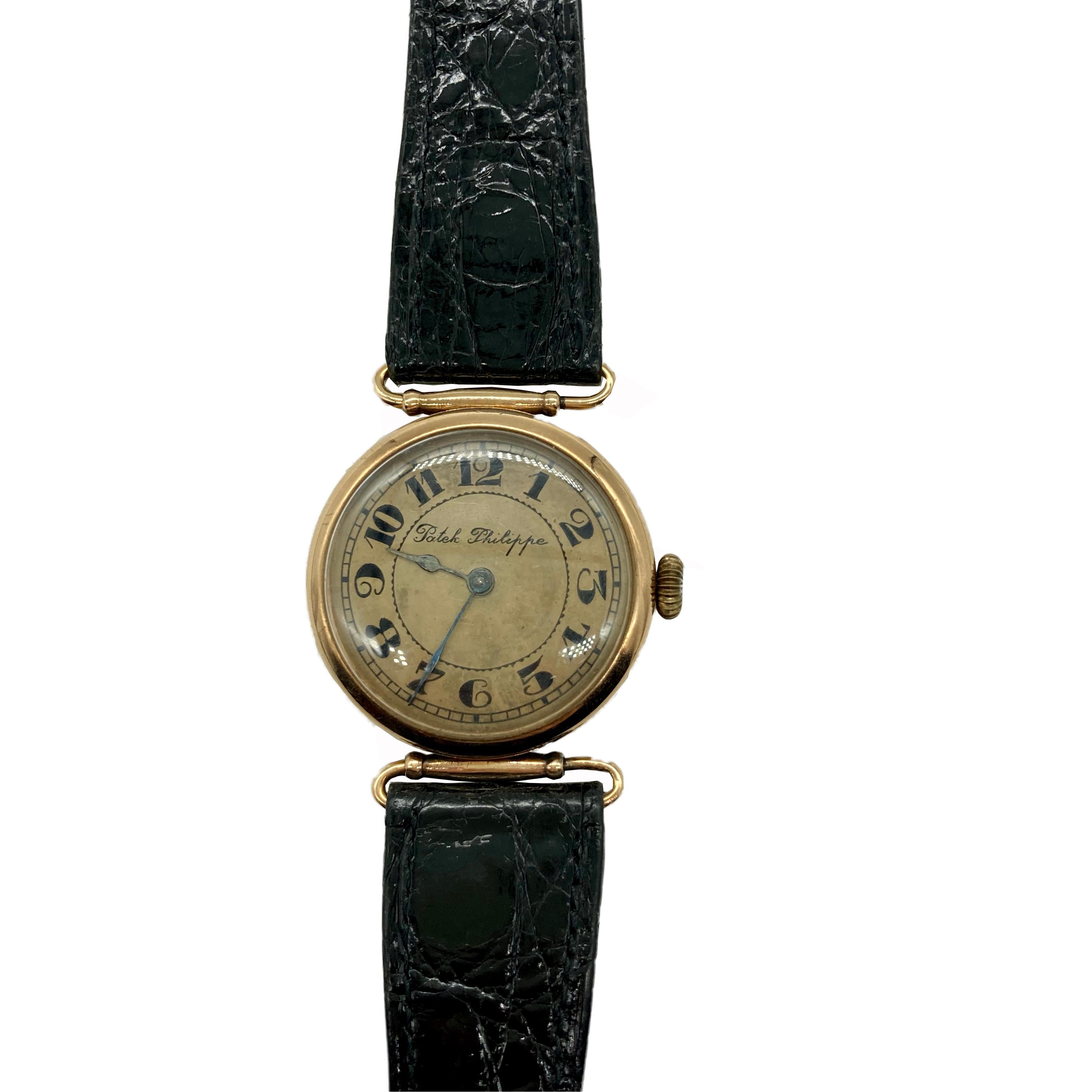 A collectible antique wristwatch by Patek Philippe featuring a rose gold dial, and a black alligator strap. Made in Switzerland, circa 1910.