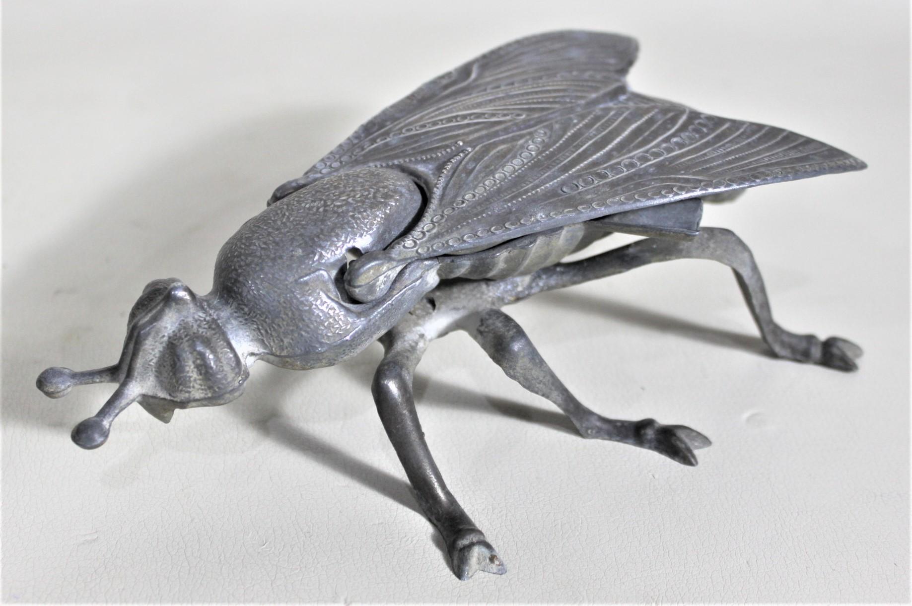 This cast and patinated metal figural ashtray is unsigned, but presumed to have been made in England in approximately 1920. This nicely cast ashtray is a wasp or hornet and it's wings are hinged and lift up to reveal the bowl of the ashtray and two