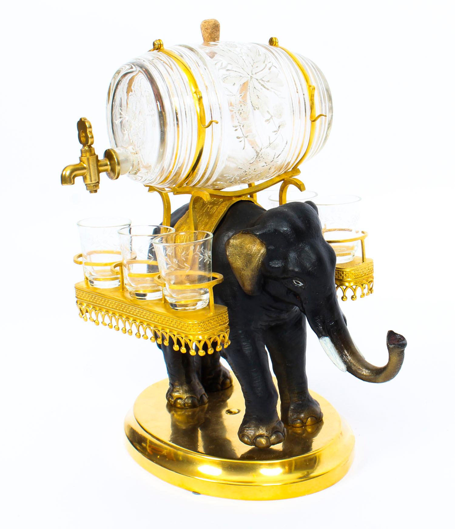 This is an extremely fine neoclassical French ornamental cast bronze, ormolu and glass liqueur set, circa 1840 in date.

This fabulous liqueur set is in the form of a finely patinated bronze sculpture of an elephant walking along and carrying an