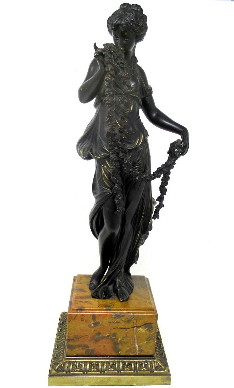 An exceptionally well cast dark patinated grand tour bronze figure modelled as a standing classical female, draped in Robes and holding long Garlands of Flowers. First half of the Nineteenth Century, possibly of French origin. 

Complete with a