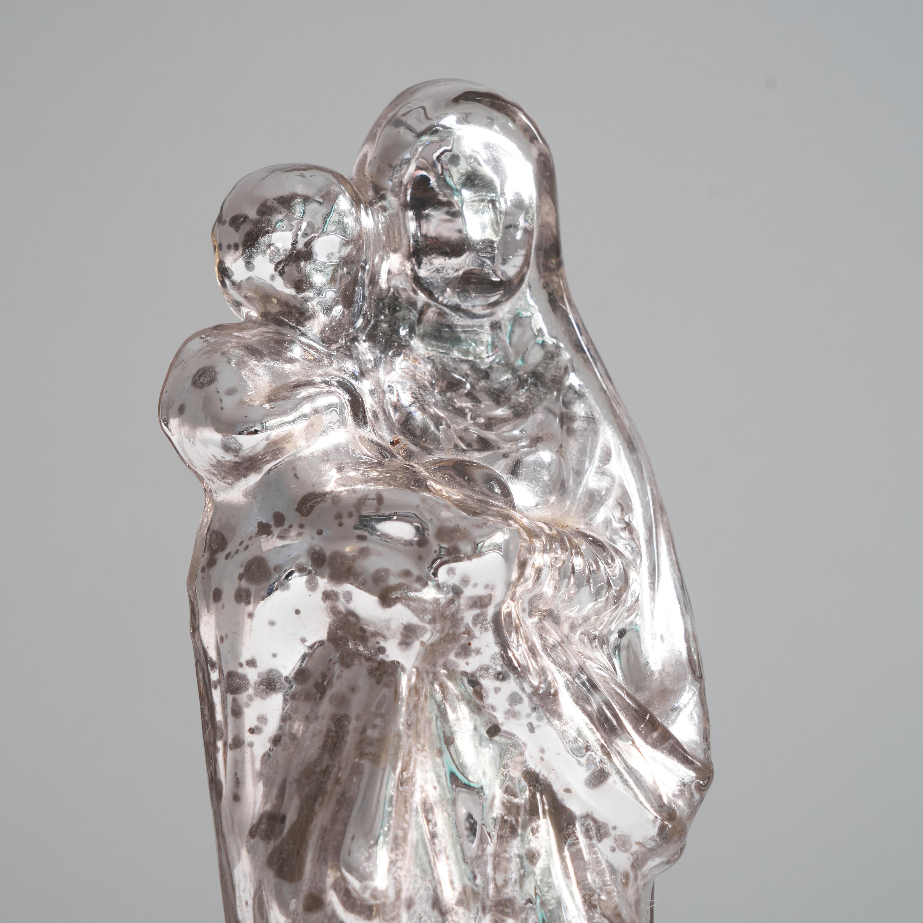 Antique Patinated Mercury glass Madonna with child. Turn of the century / Early 20th century. 

This is a wonderful mercury glass Madonna with child figurine. It is made of molded glass with a silvered interior, creating a visually very pleasing