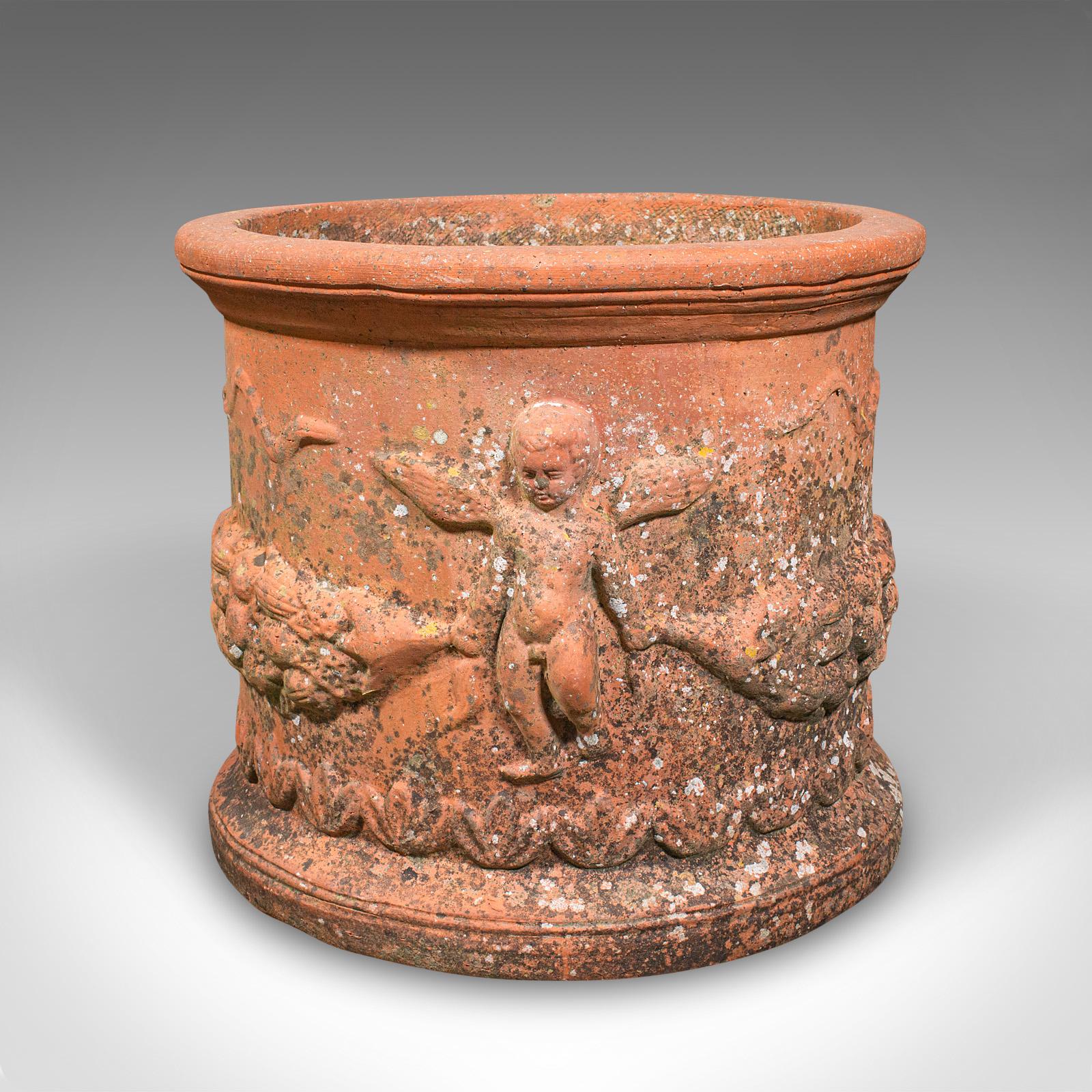 This is an antique patio jardinière. An English, terracotta planter in classical Cherubic taste, dating to the Edwardian period, circa 1910. Offering wonderful decorative appeal and fine weathered character, this charming piece would make a superb