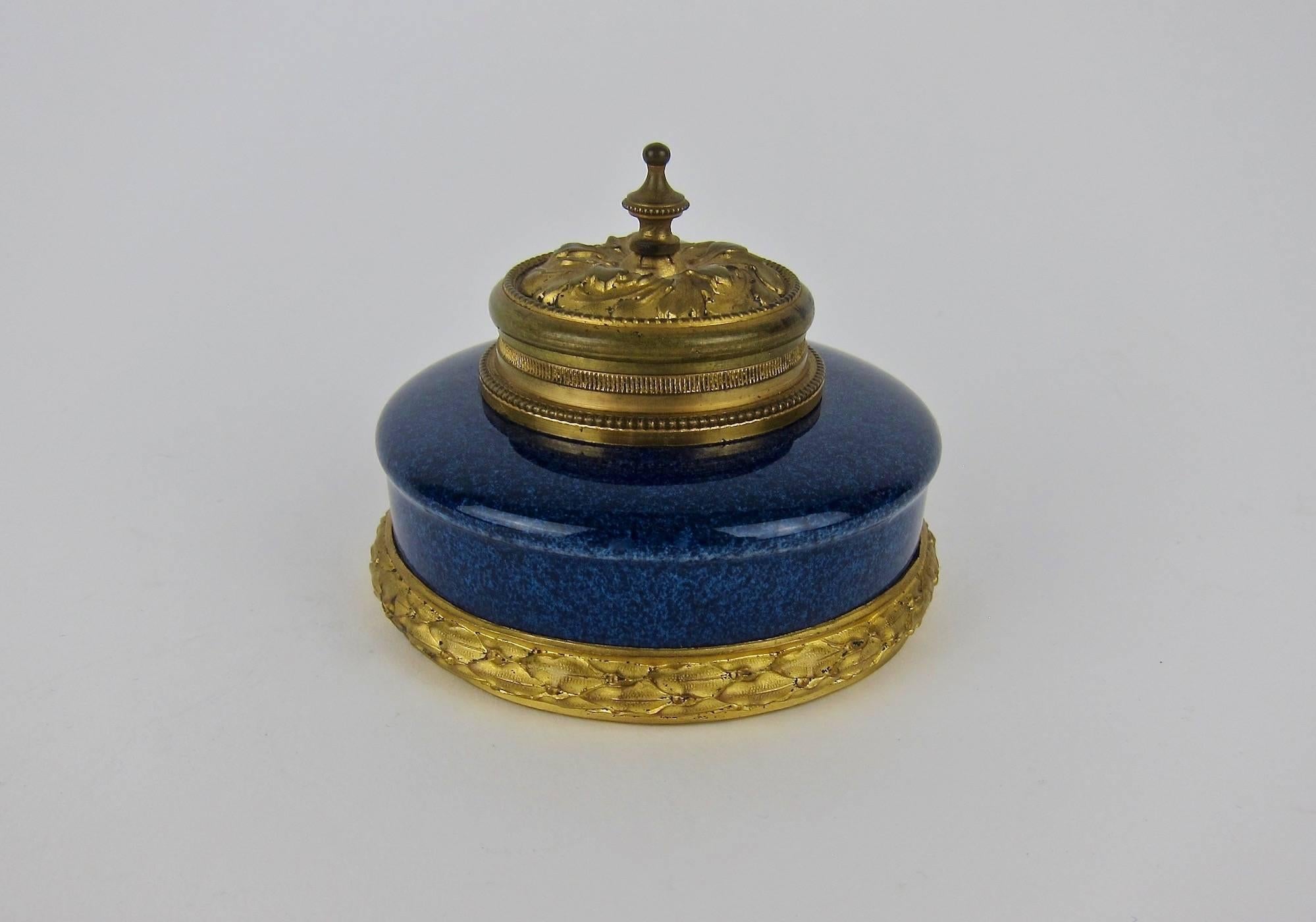 An antique French inkwell in glazed faience with contrasting ormolu mounts and lid in the French Neoclassical style, designed by Paul Jean Milet (1870-1950) for the Paul Milet Pottery at Sèvres, France, circa 1915. The inkwell's exterior is