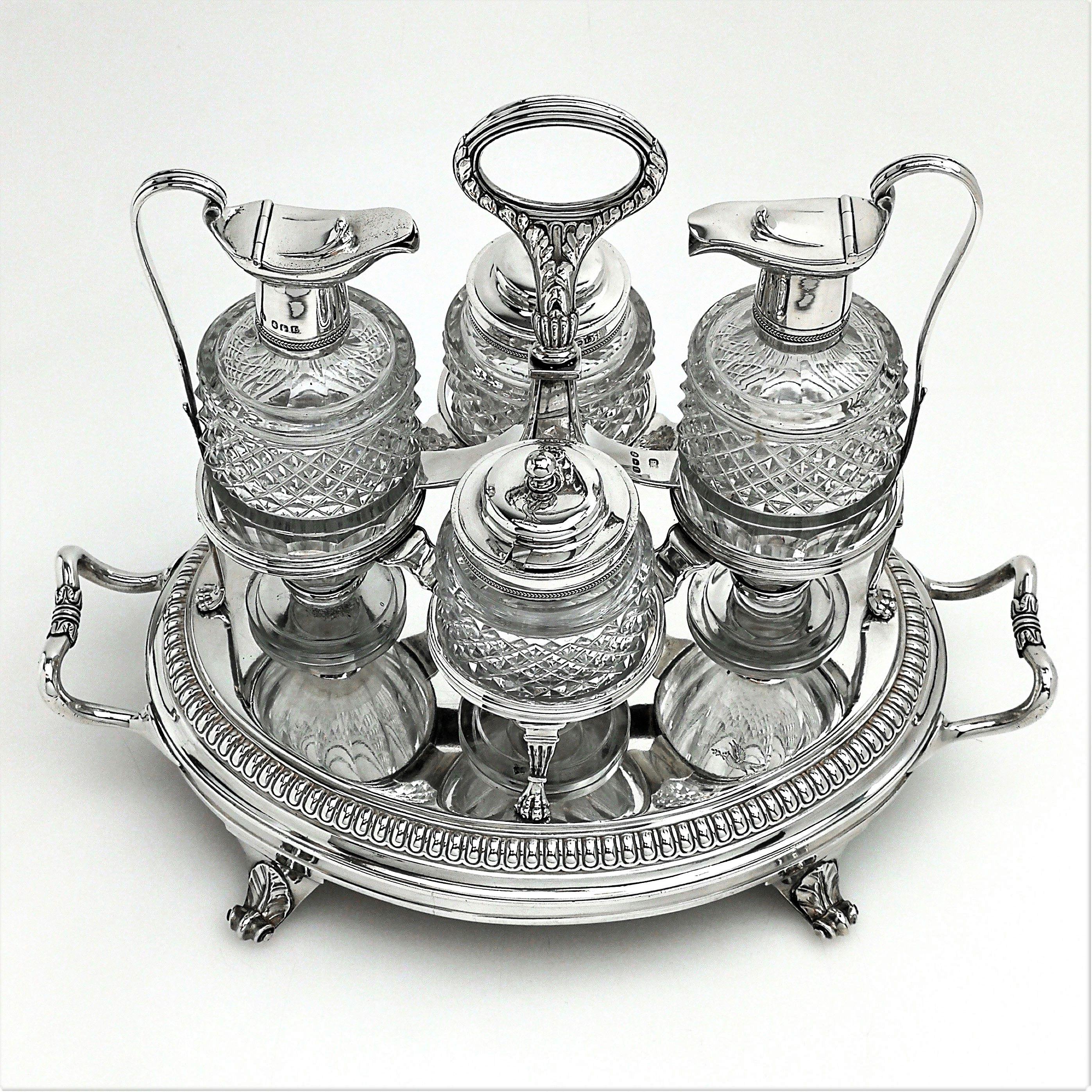 An impressive antique George III sterling silver and cut glass cruet set by the esteemed silversmith Paul Storr. This set is presented in a substantial, heavy solid silver cruet stand on four acanthus leaf topped scroll feet. The cruet stand bottles