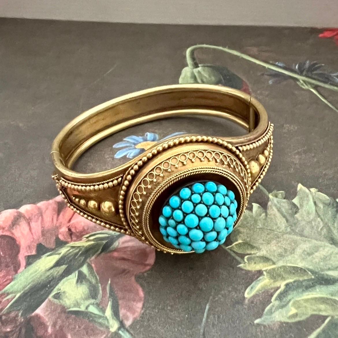 Un braccialetto bangle in oro 18 carati e turchese, di ottima fattura, di epoca medio-vittoriana. Il bracciale è incastonato con una cupola di pavé di pietre turchesi circondata da un motivo a corda, cannetille e perline dorate. Il design sul retro