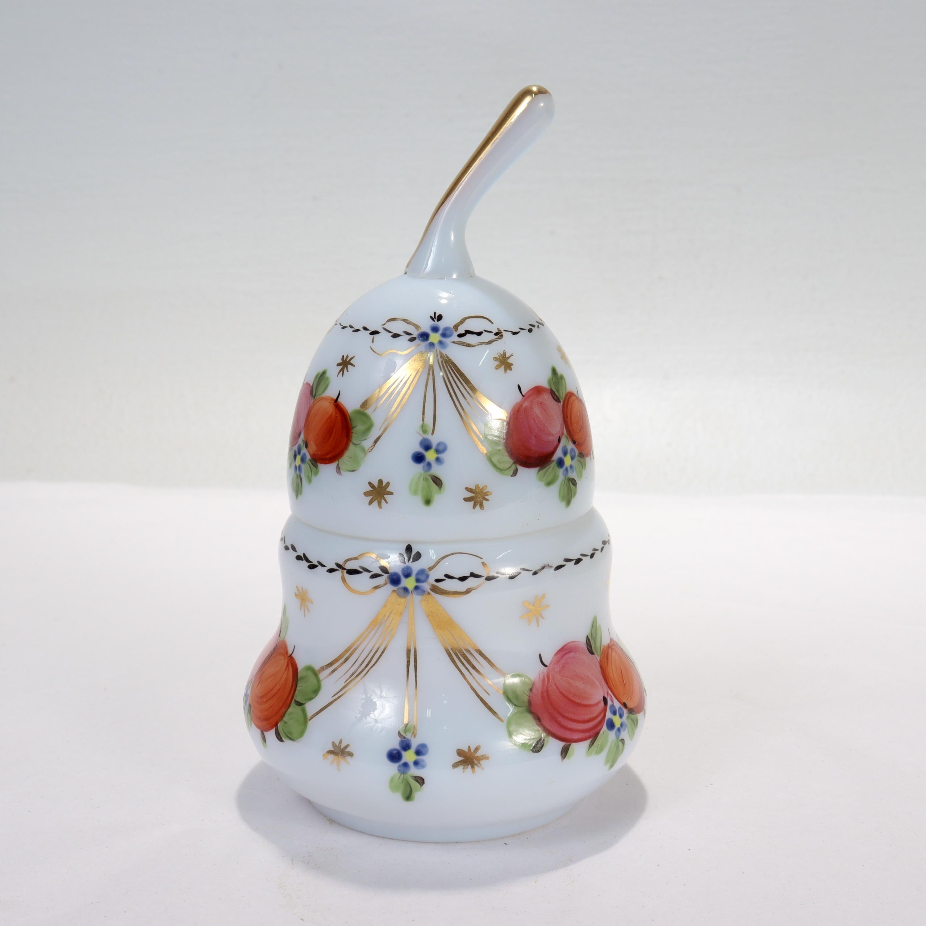 A fine opaline (likely French) glass box.

In the stylized form of a pear.

The white opalescent glass body and lid both have handpainted fruit and floral decoration & rich gilding throughout. 

Simply a wonderful dresser box!

Date:
Early
