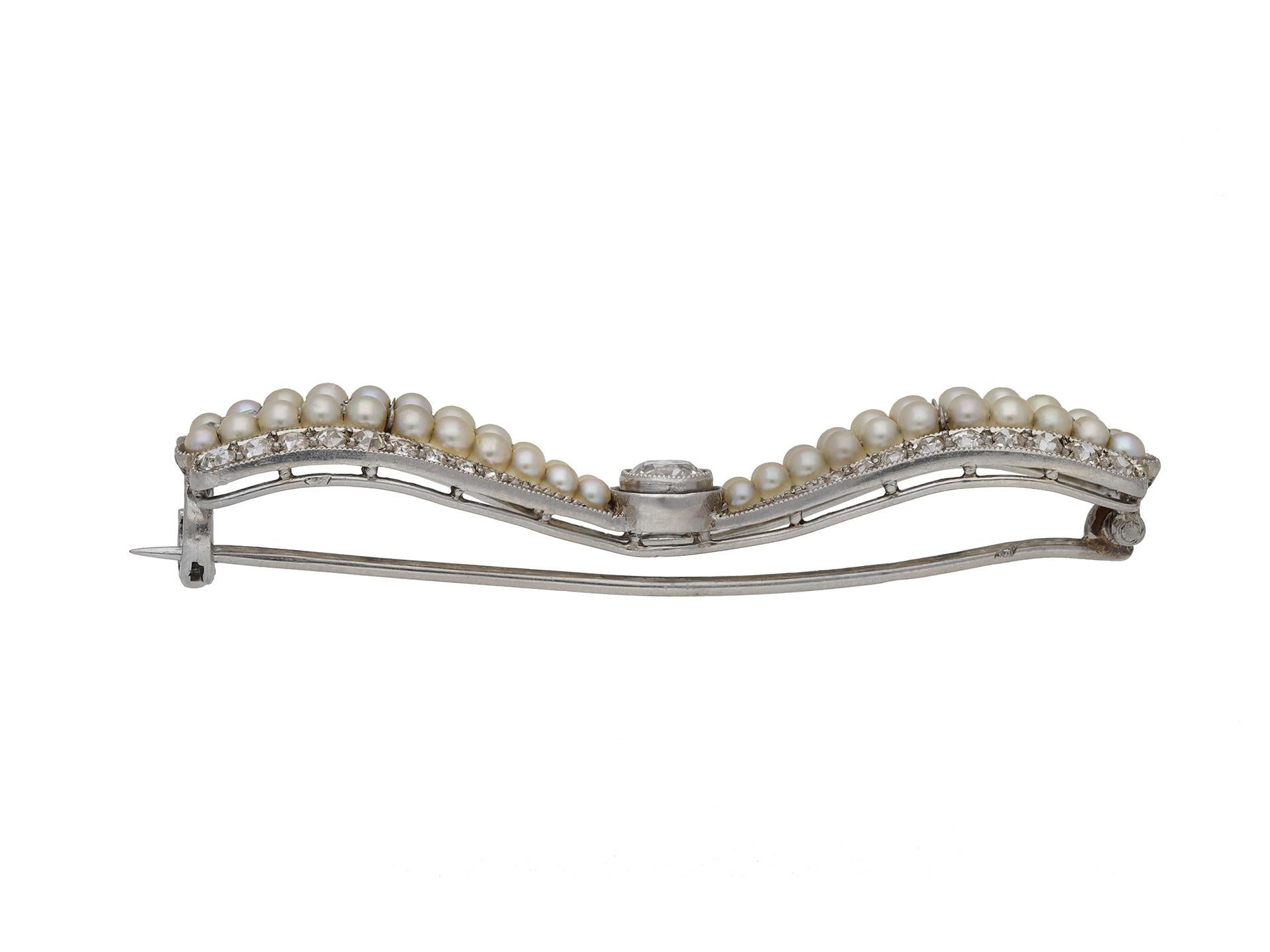 Antique pearl and diamond bow brooch. Set with a central round old cut diamond in an open back rubover setting with a weight of 0.25 carats, leading out to a triple row of fifty four round old cut diamonds with a combined weight of 1.50 carats and a