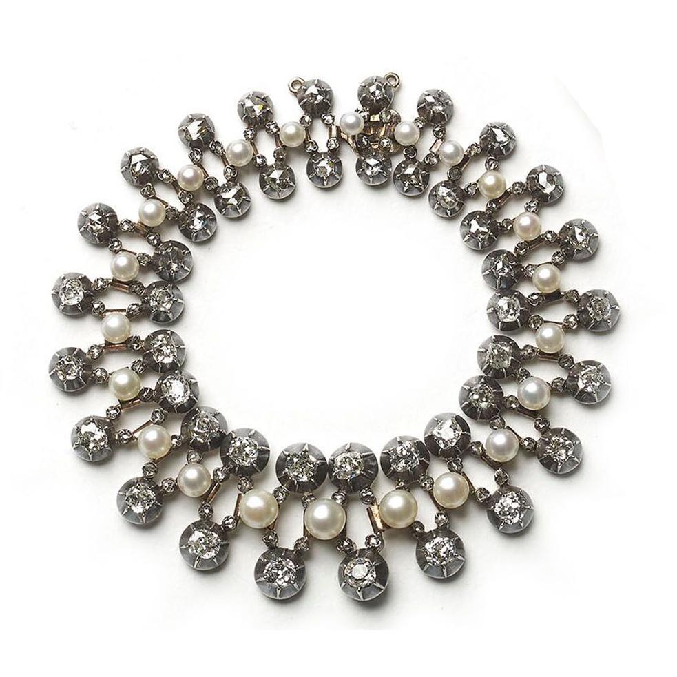 An antique, natural pearl and old-cut diamond set bracelet. The bracelet has a central row of graduating pearls, with a row, either side, set with graduating old-cut diamonds, in cut down settings. The links are spaced with rose-cut diamonds,