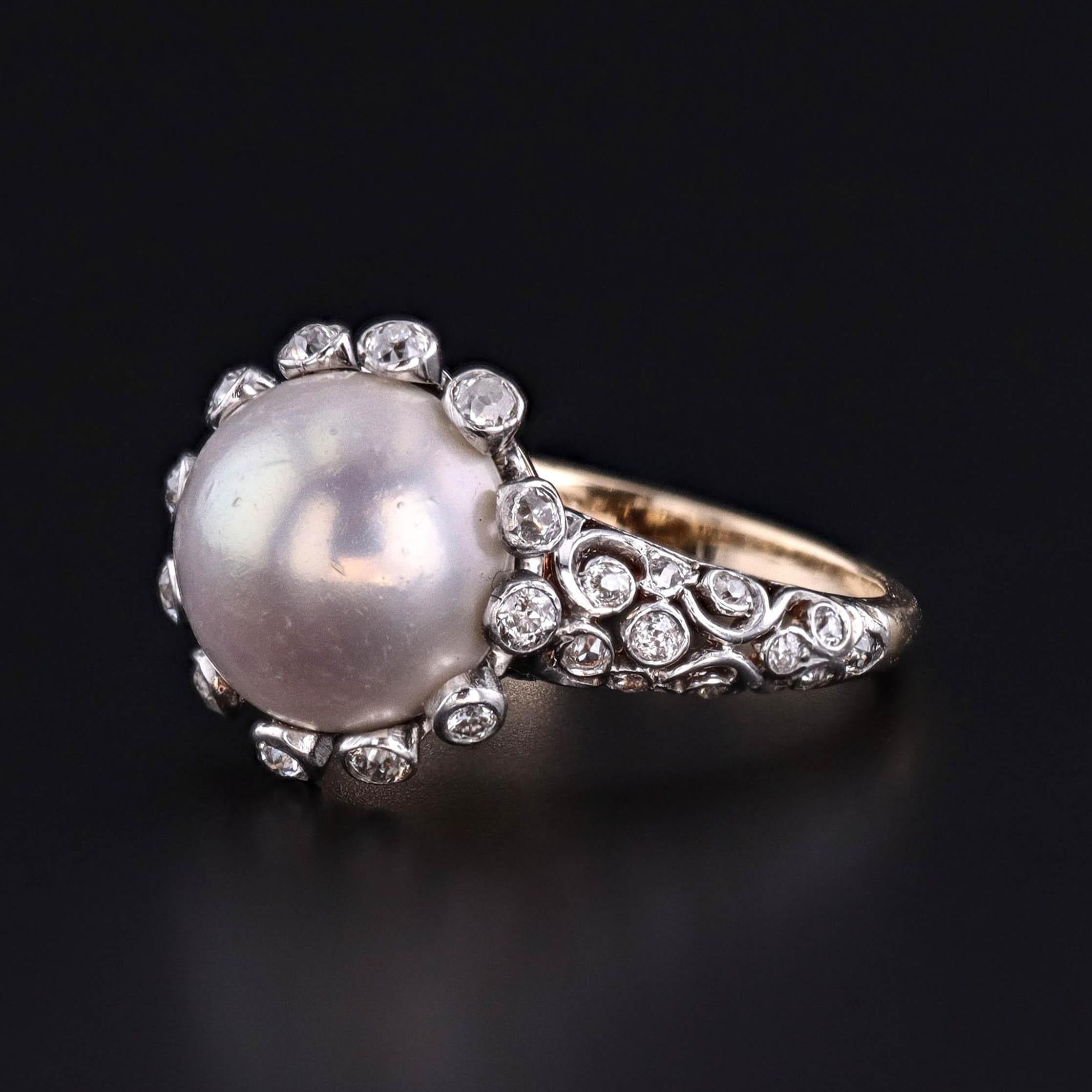 Gioiello di eleganza e raffinatezza, questo anello antico (circa 1900-1910) presenta una perla a bottone di 10,5 mm con un'elevata lucentezza circondata da un'aureola di scintillanti diamanti di taglio europeo antico. I diamanti sono incastonati nel