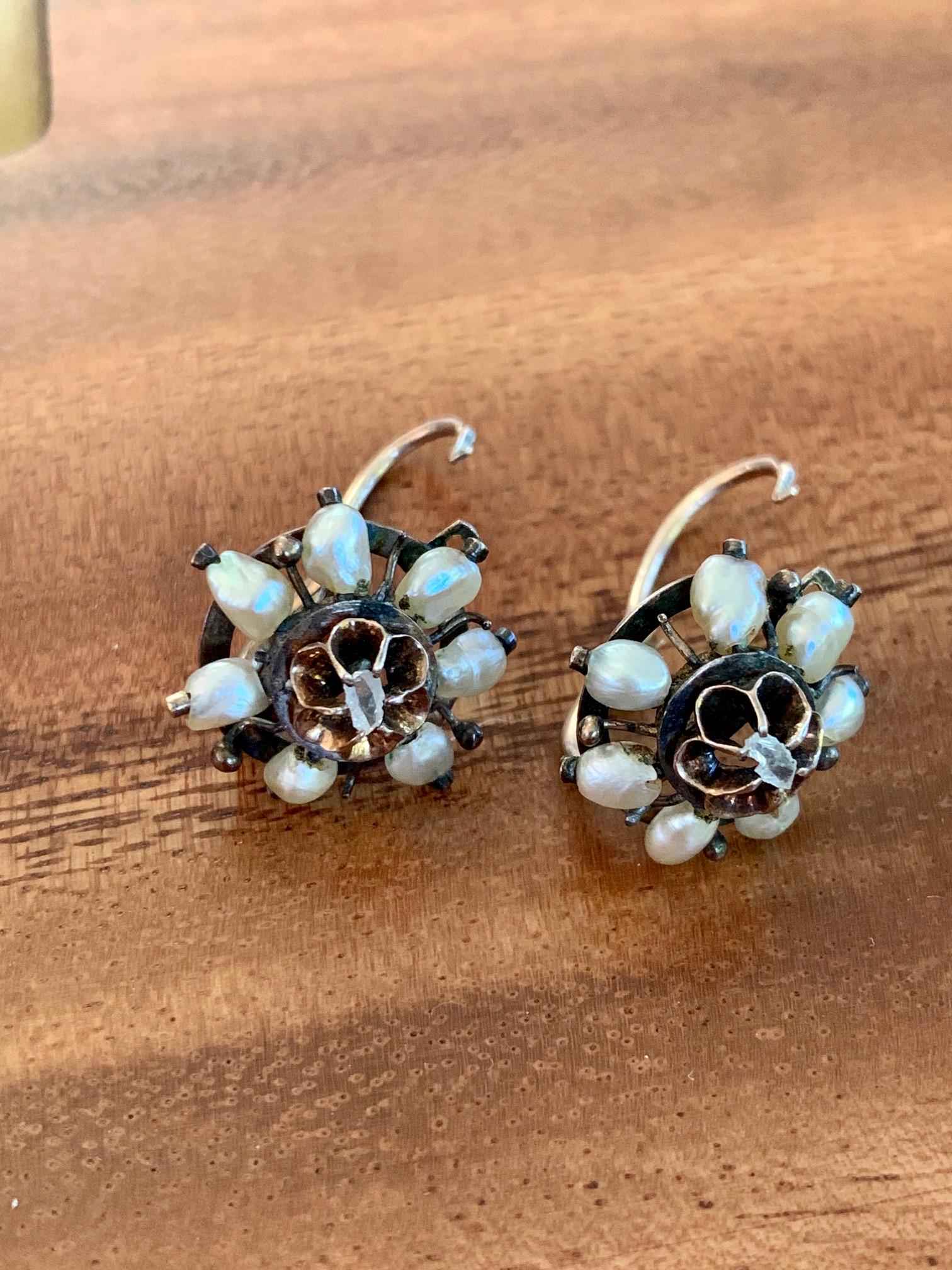 These antique Pearl and Rose Cut Diamond earrings are from the late 1800's, approximately 1880-1900.   Each earring has seven pearls surrounding the rose cut Diamond center stone. 

Closure: Front Hook 
Weight: 5.8 grams