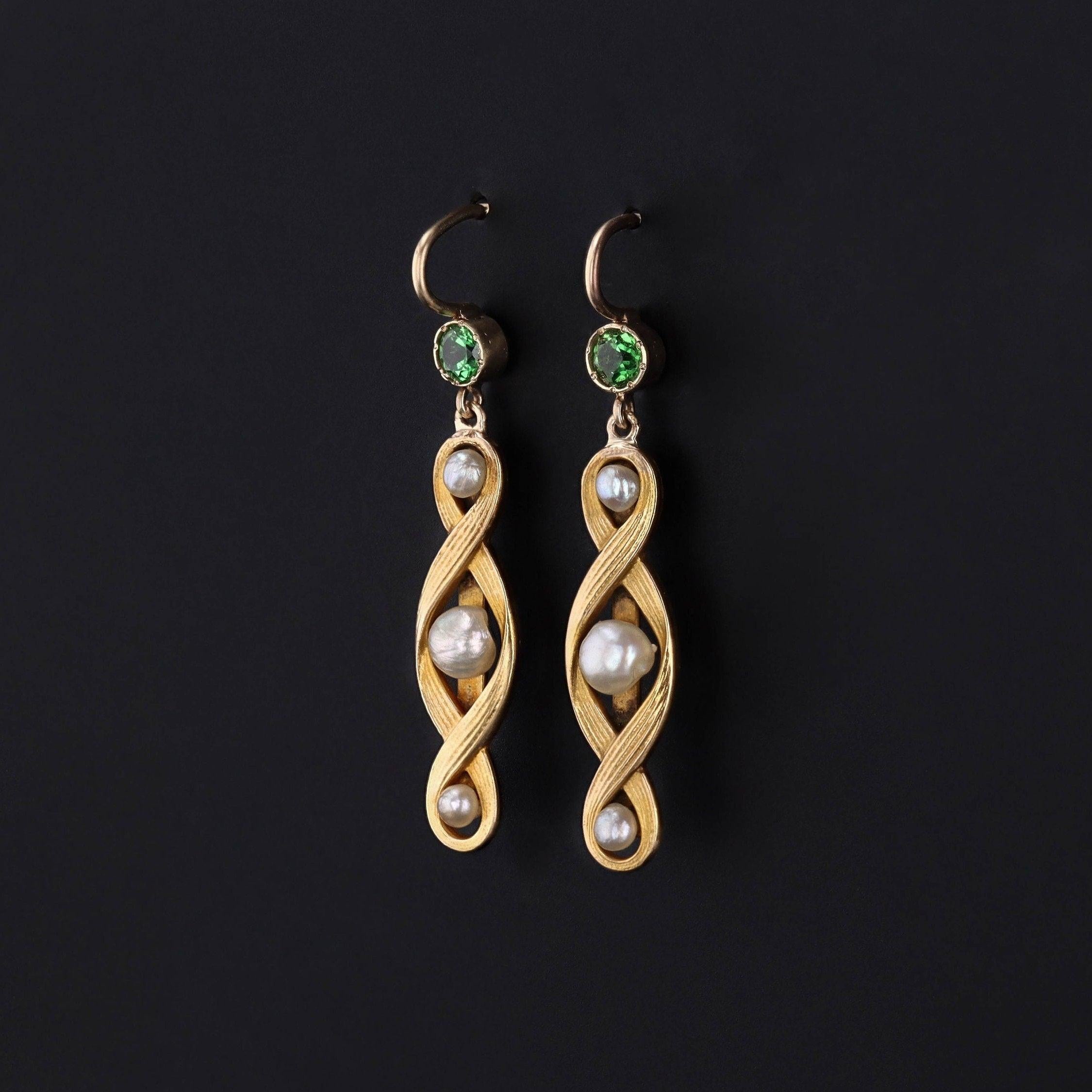 Orecchini pendenti con perle creati a partire da antichi perni a barra (circa 1910-1920), rimuovendo i risultati dei perni e saldando i fili in oro 14k con sormonti di granato tsavorite verde.

Ogni ciondolo in oro 14k misura 1,4 pollici dalla parte