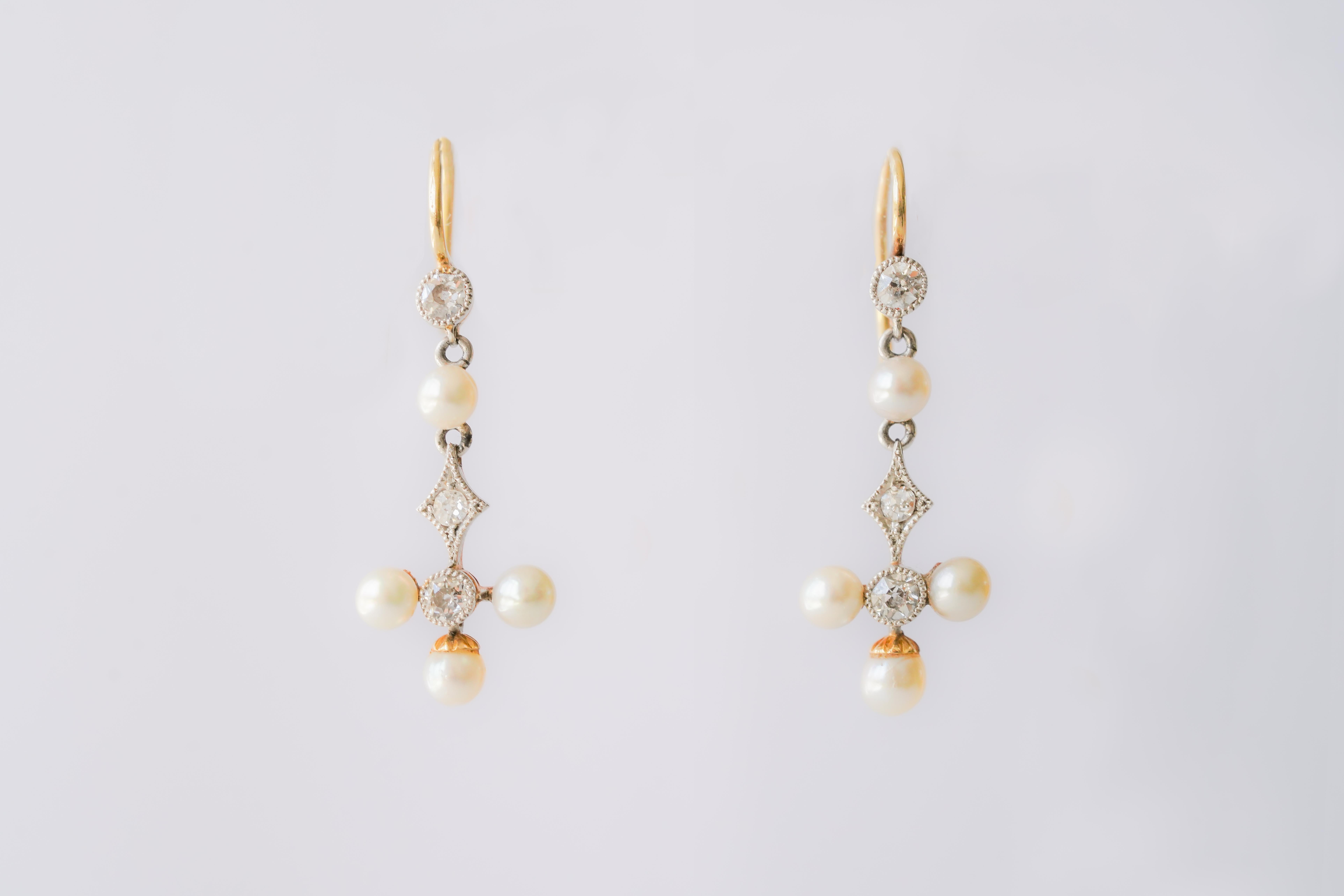 Pendientes colgantes antiguos de diamantes y perlas formados por tres secciones móviles. Acabado con herrajes de gancho francés dorados. Los tres diamantes están engastados, complementados por cuatro perlas engastadas en oro y posiblemente en plata.