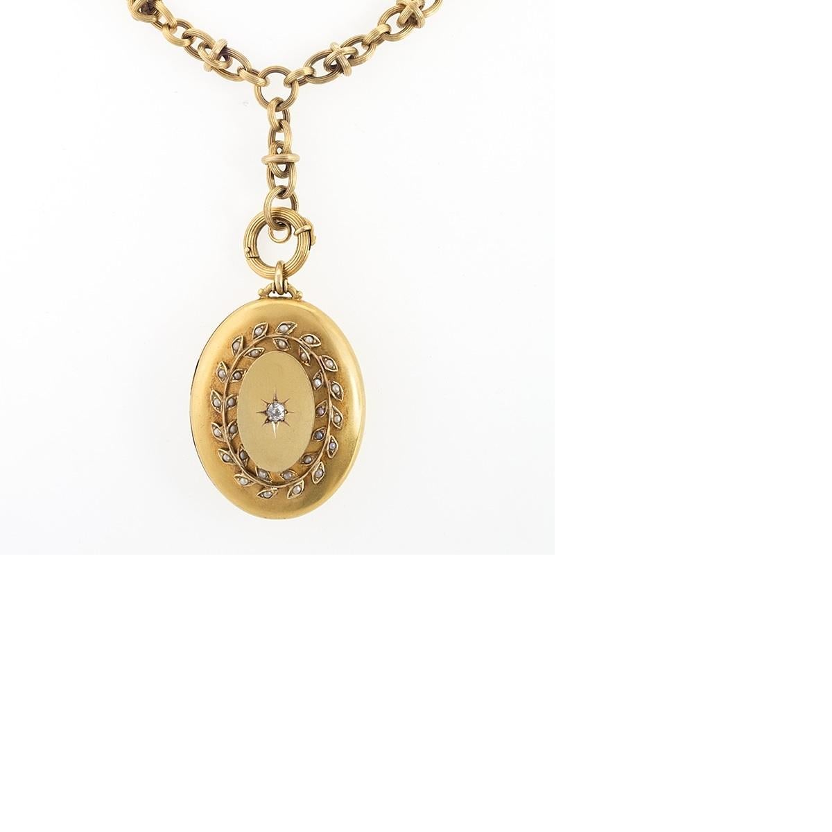 An English antique 18 karat gold pendant locket with diamonds. The pendant locket has 1 old mine-cut diamond with an approximate total weight of .18 carat, which is surrounded by a seed pearl-set garland.  The locket is suspended from an antique 18
