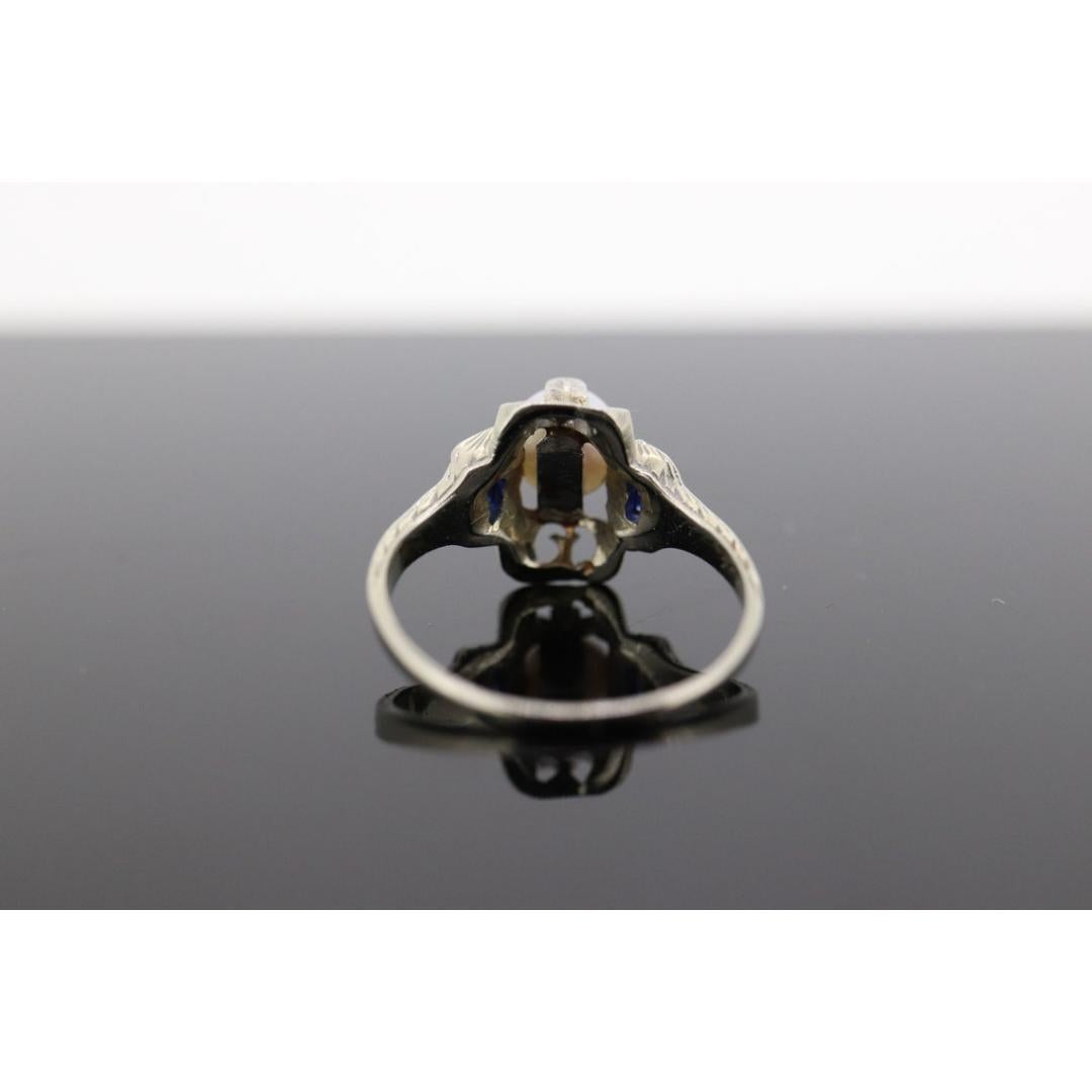 Vintage from the 1950s
Size: 5 US
Materials: Gold
Gemstone: Pearl
Gem color: White
Band color: White
Style: Art deco

About this item

Very beautiful Art Deco pearl and sapphire ring. Large pearl solitaire with sapphire accents.

Rare 20k white gold