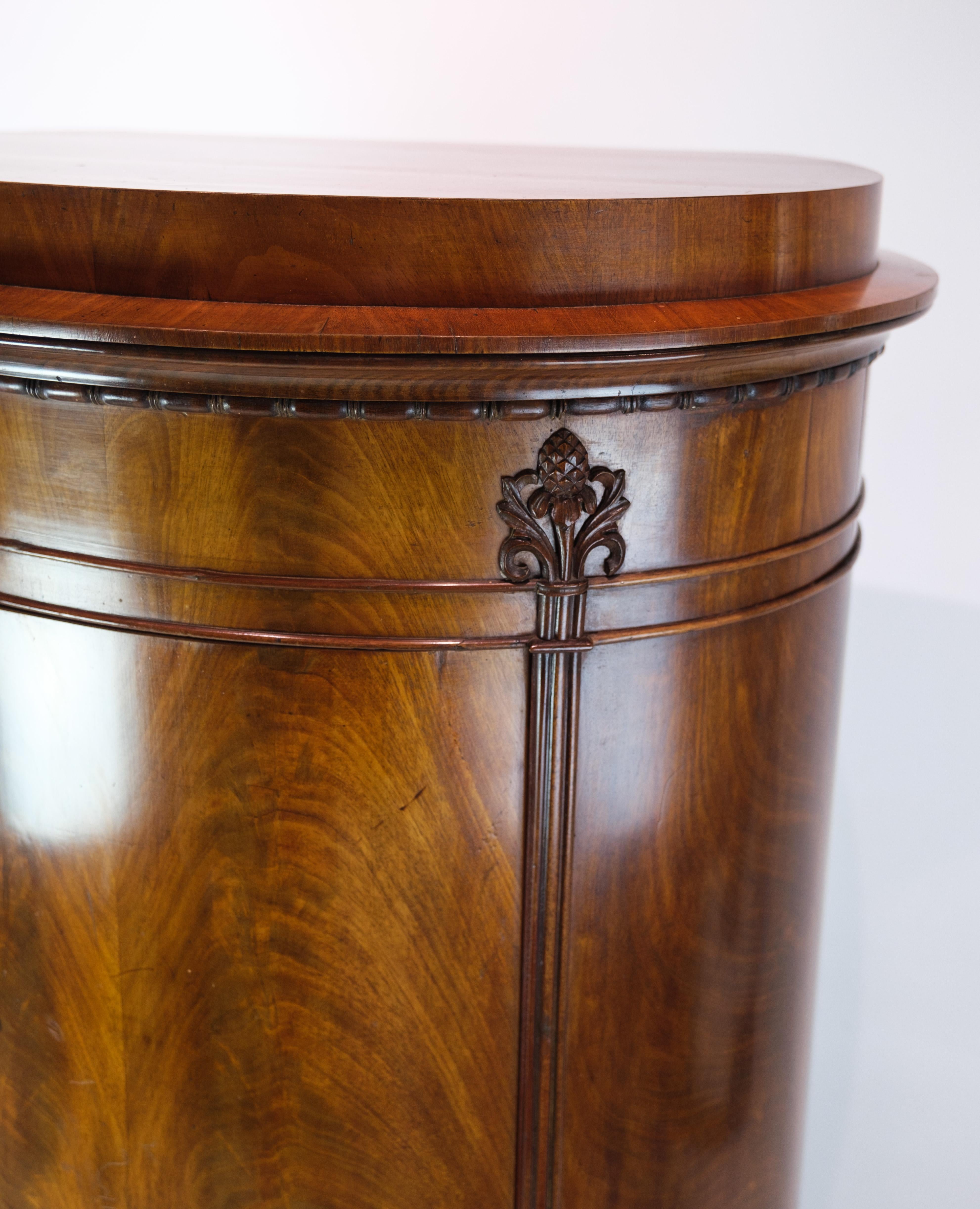 Antique mahogany pedestal cabinet with carvings and beautiful structure in the wood from around the 1840s.
Measurements in cm: H:138, W:64, D:38.