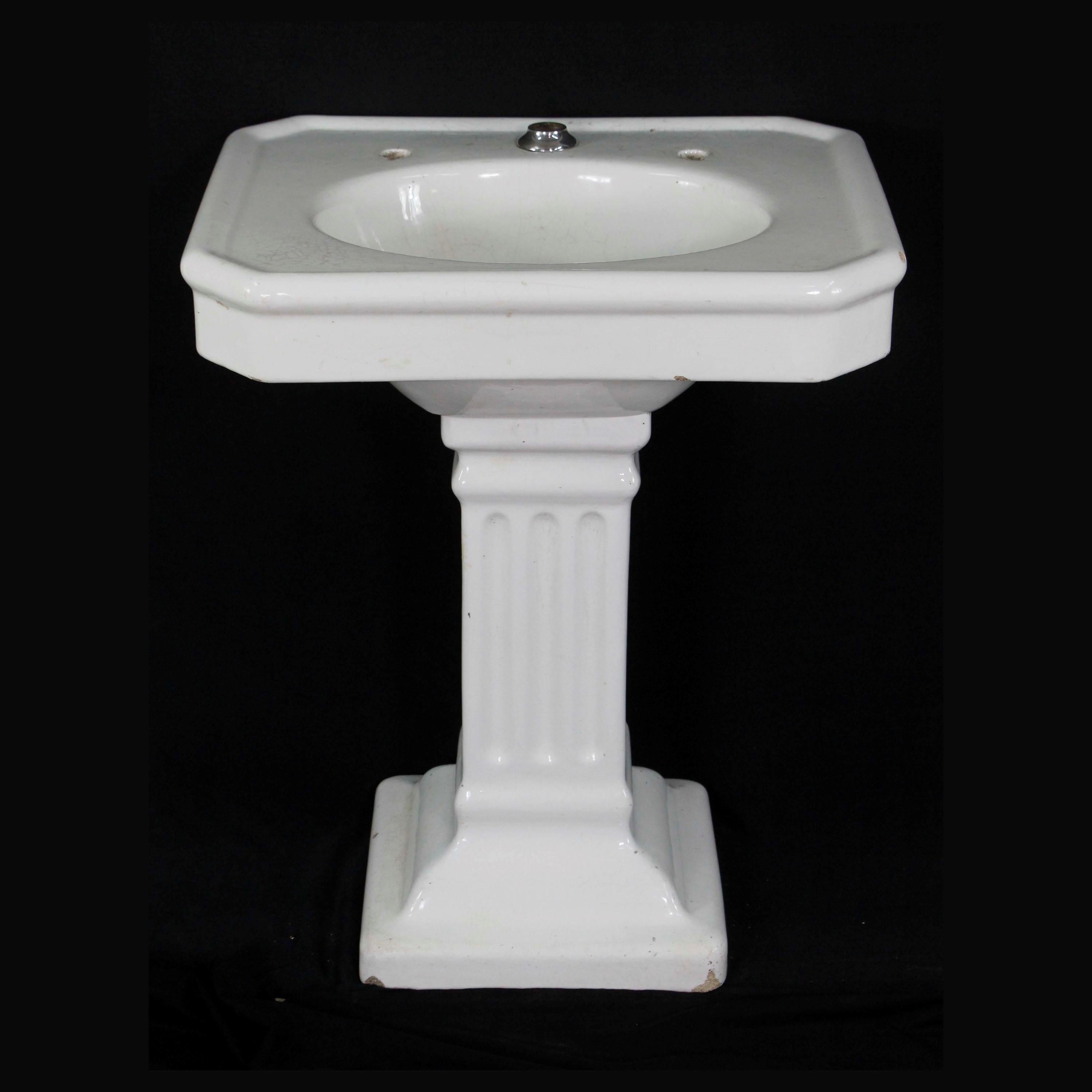 Antique cast earthenware pedestal sink with white porcelain glaze and fluted base. It has a crackled glaze which adds to its beauty. There are some chips along the top and the base. Please see the photos. No hardware is included. 

