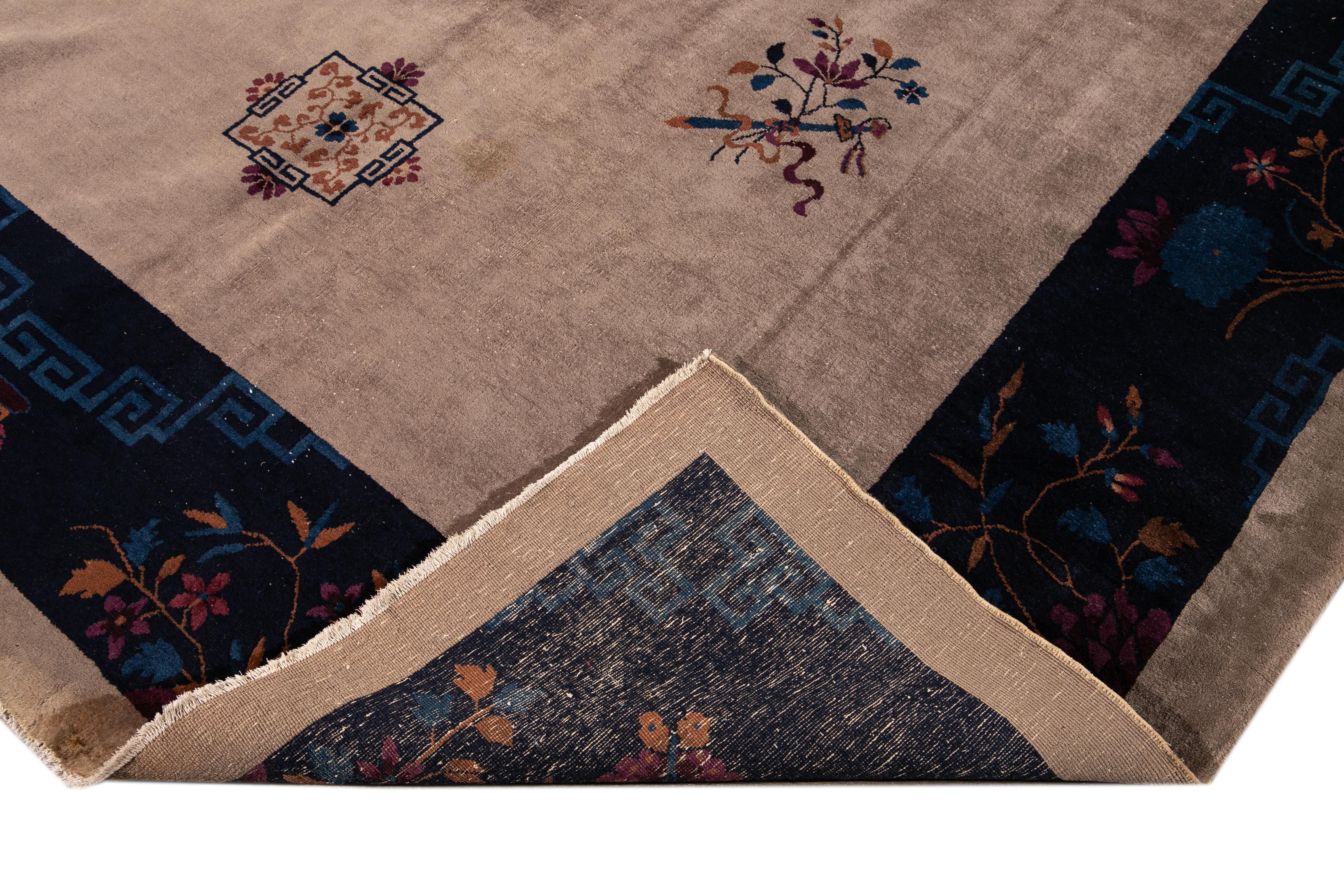 Preciosa alfombra antigua china de Pekín, anudada a mano, de lana con campo marrón. Esta alfombra china tiene un marco azul, detalles multicolores en un precioso diseño floral de medallón chino. 

Esta alfombra mide 10' x 13'7