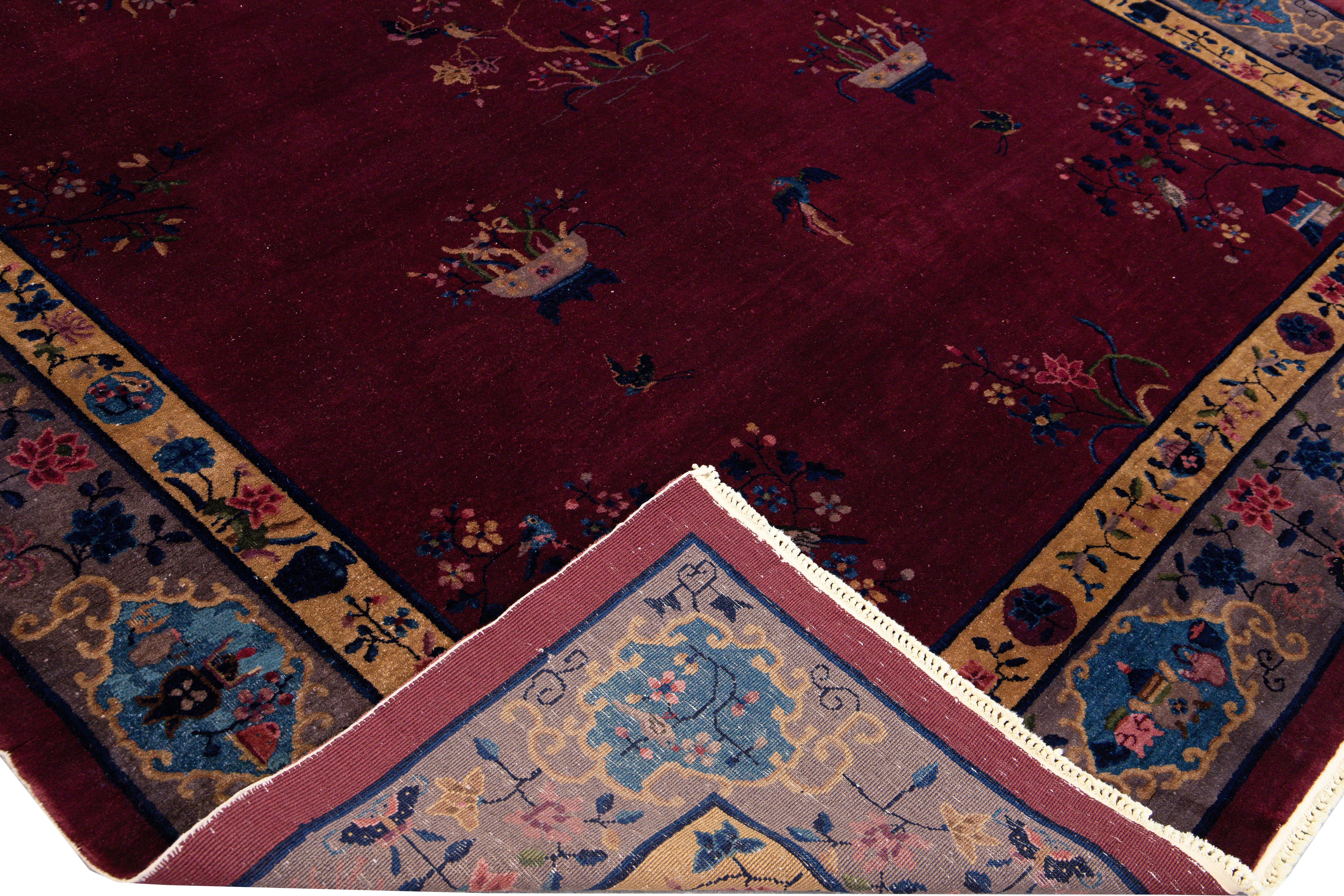 Magnifique tapis chinois ancien en laine nouée à la main avec un champ bordeaux. Ce tapis chinois présente un cadre violet, des accents multicolores et un magnifique motif floral chinois. 

Ce tapis mesure : 9'4