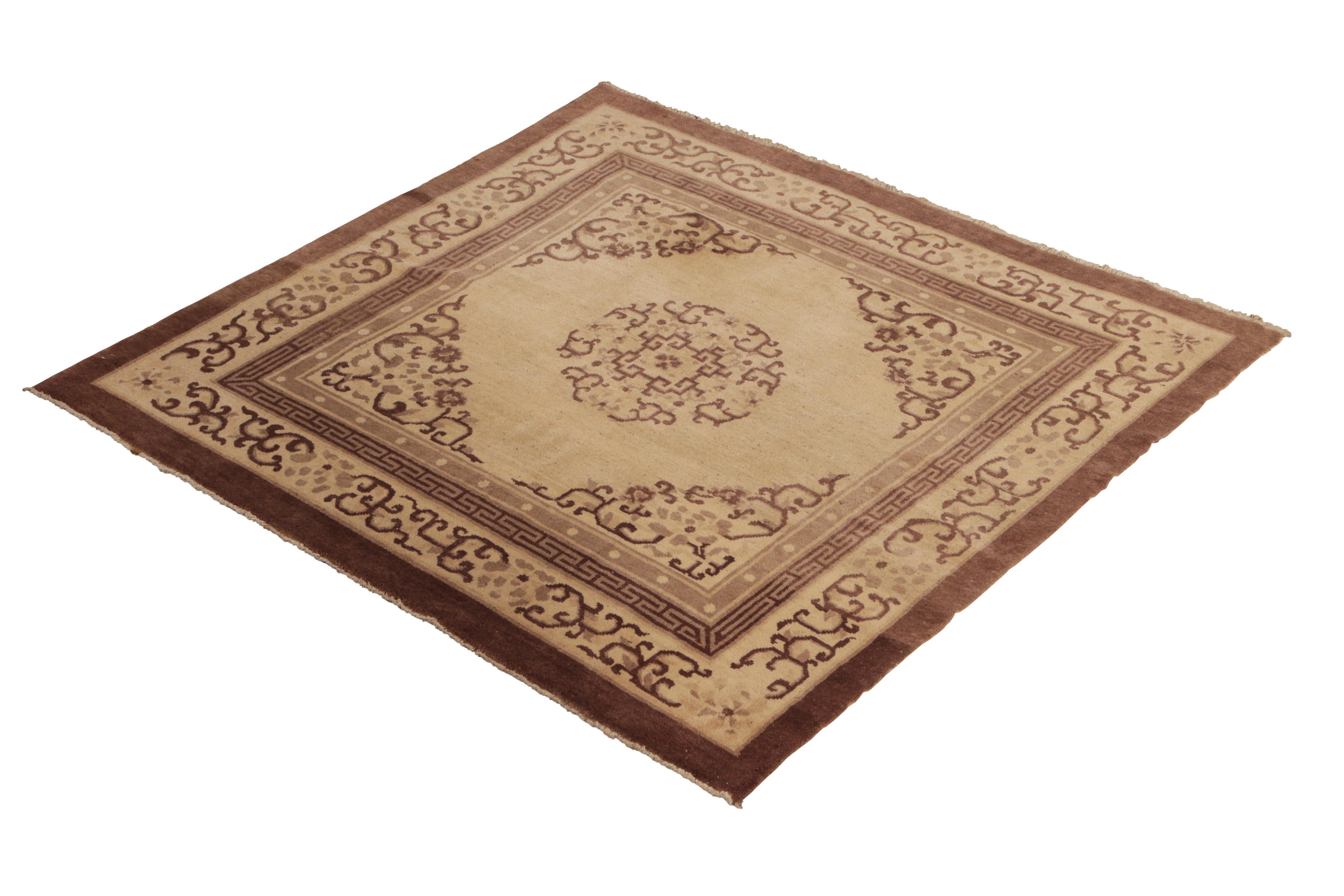 Hand knotted in wool originating from China, circa 1920, this antique rug connotes a Peking Art Deco design in a rich traditional pallet of beige and brown colorways, with subtle notes of taupe gray gracefully drawing the eye to the refinement of