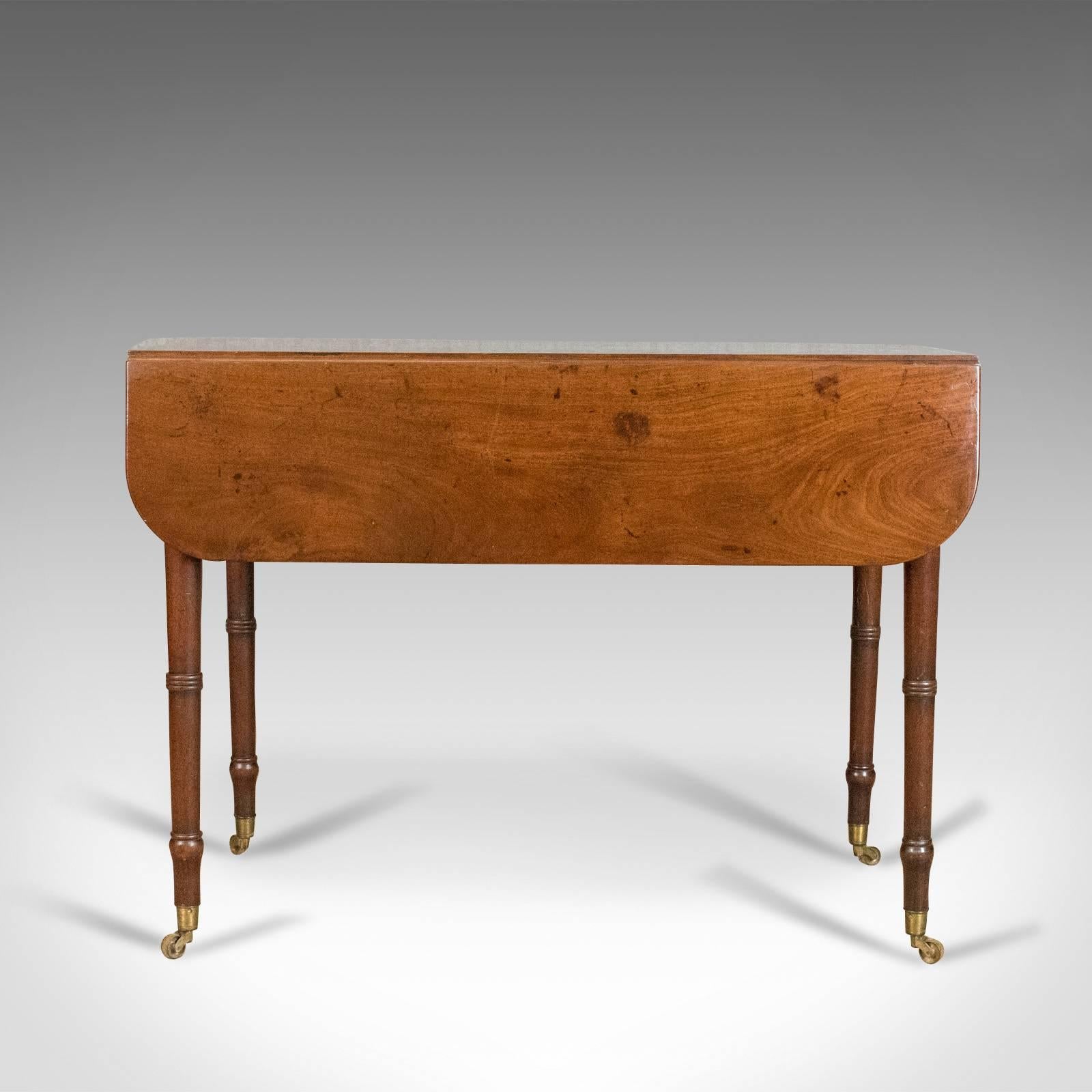 This is an antique pembroke table in mahogany. An English, Georgian drop flap dining table dating to circa 1820.

Fine example in select mahogany with attractive mid-tone pallet
Grain interest with desirable aged patina
Elegant