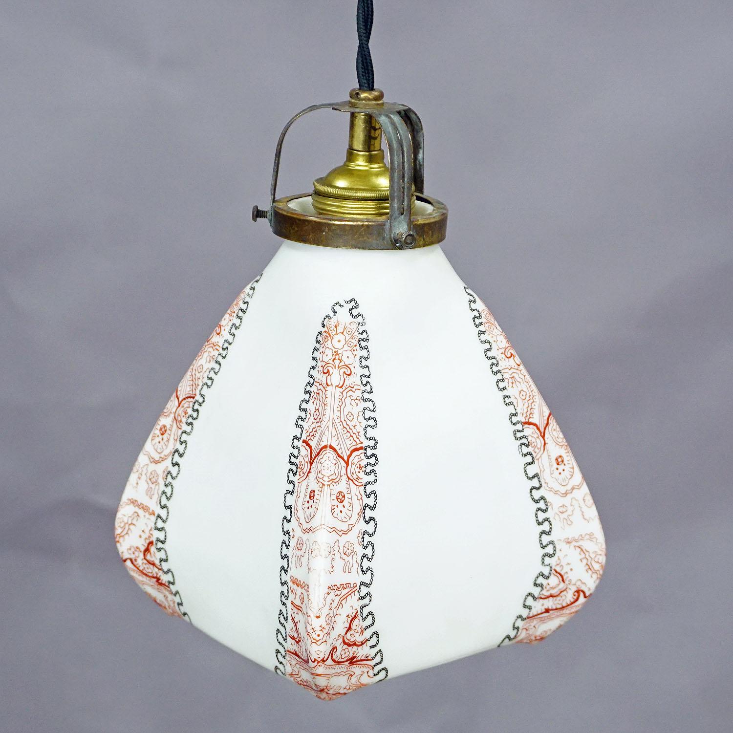 an antique functionalistic pendant lamp with a white opaline glass shade with printed black and red decor on the edges cabling renewed, working order with international E27 base lamp holder.

Measures: Width: 5.51